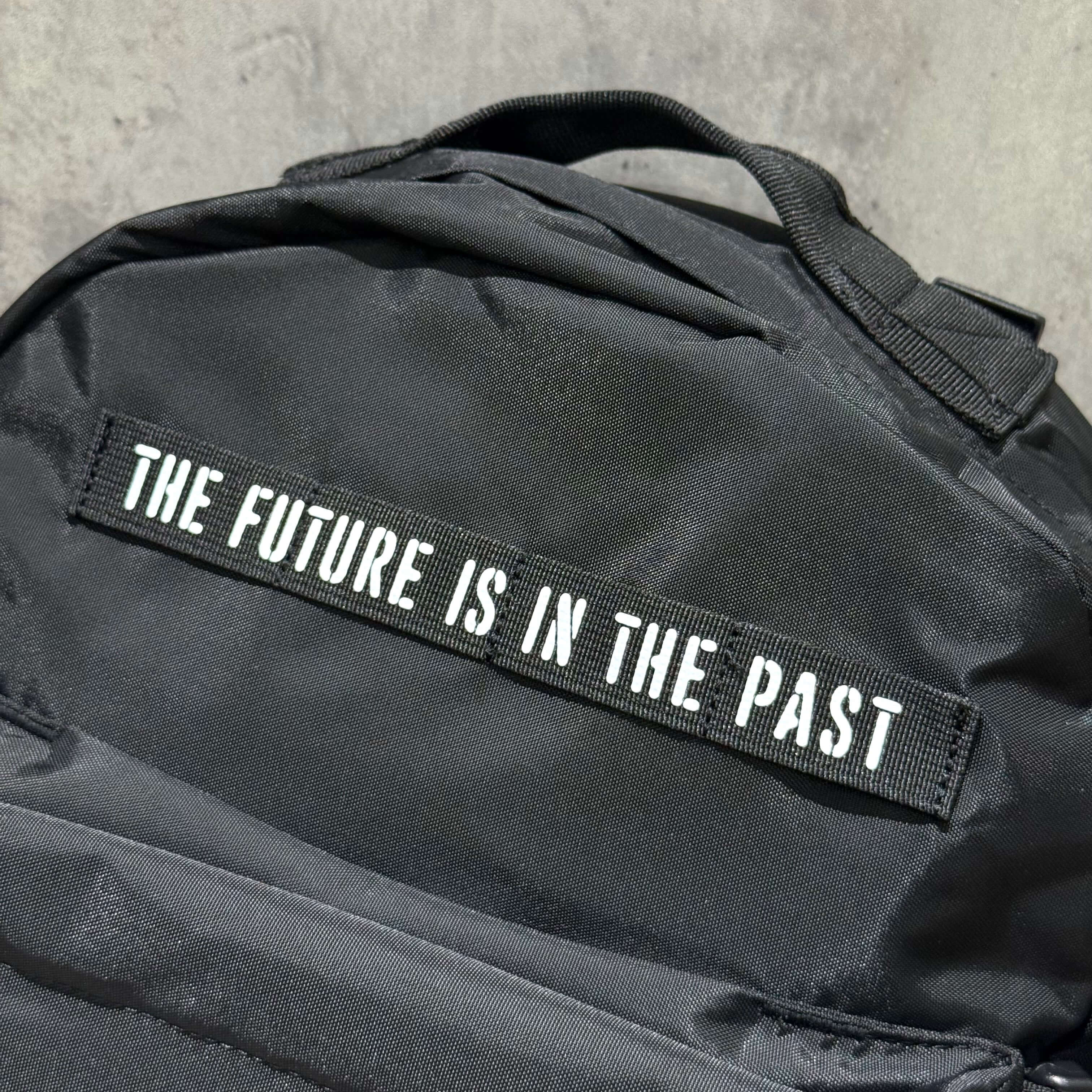 Close-up of Human Made Military Backpack featuring the text 'The Future Is In The Past' on the side.