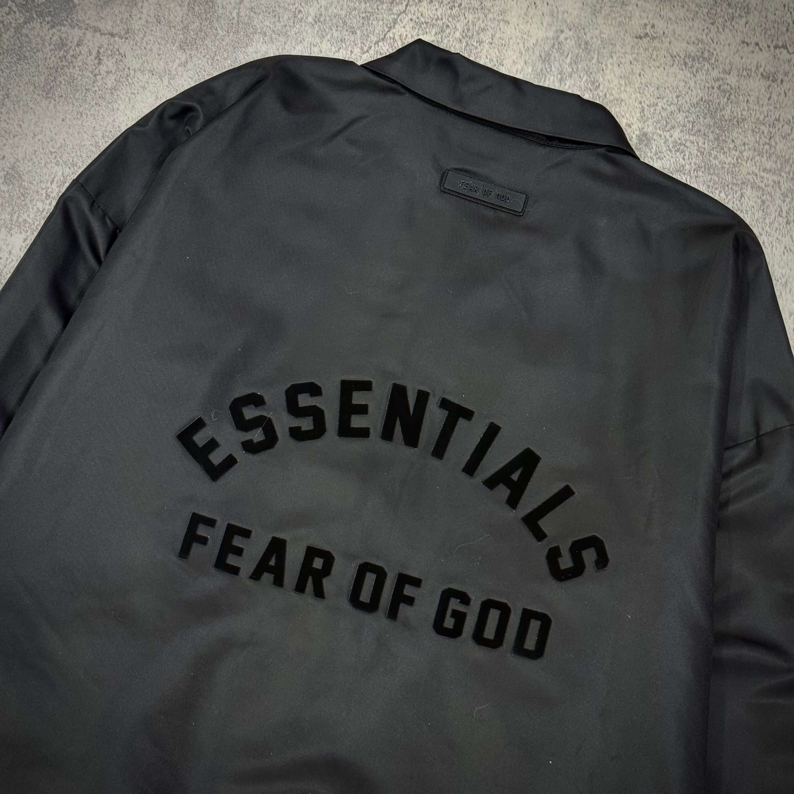 現貨 FOG Essentials Coaches Jacket SS23 - Jet Black 背面圖案，印有 ESSENTIALS FEAR OF GOD 字樣