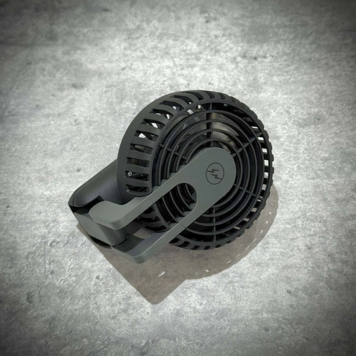 Fragment Design x Cado Mini Handy Fan in sleek dark gray color with unique design and adjustable handle.