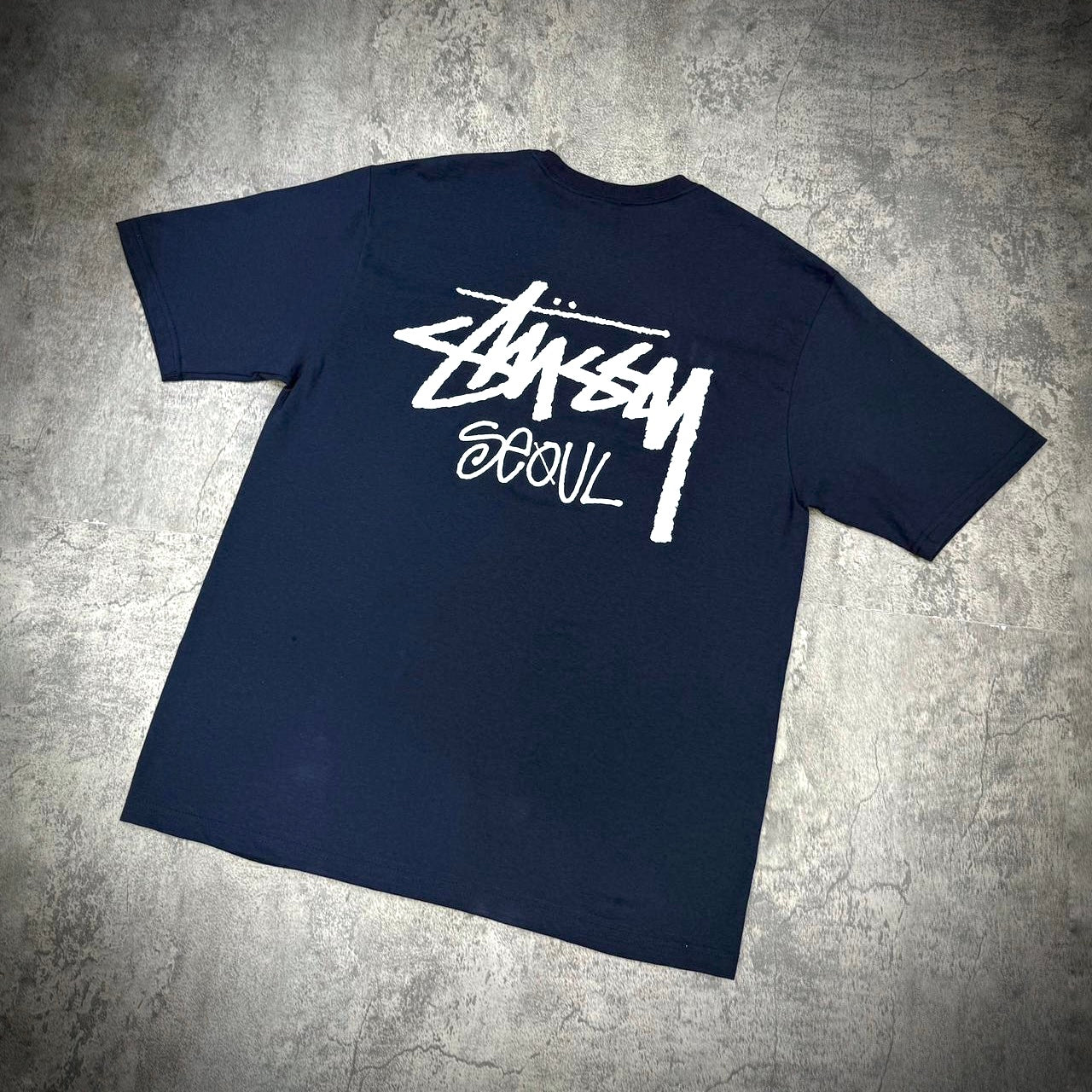 Stussy Seoul exclusive logo tee in black, featuring a white logo design on the back.