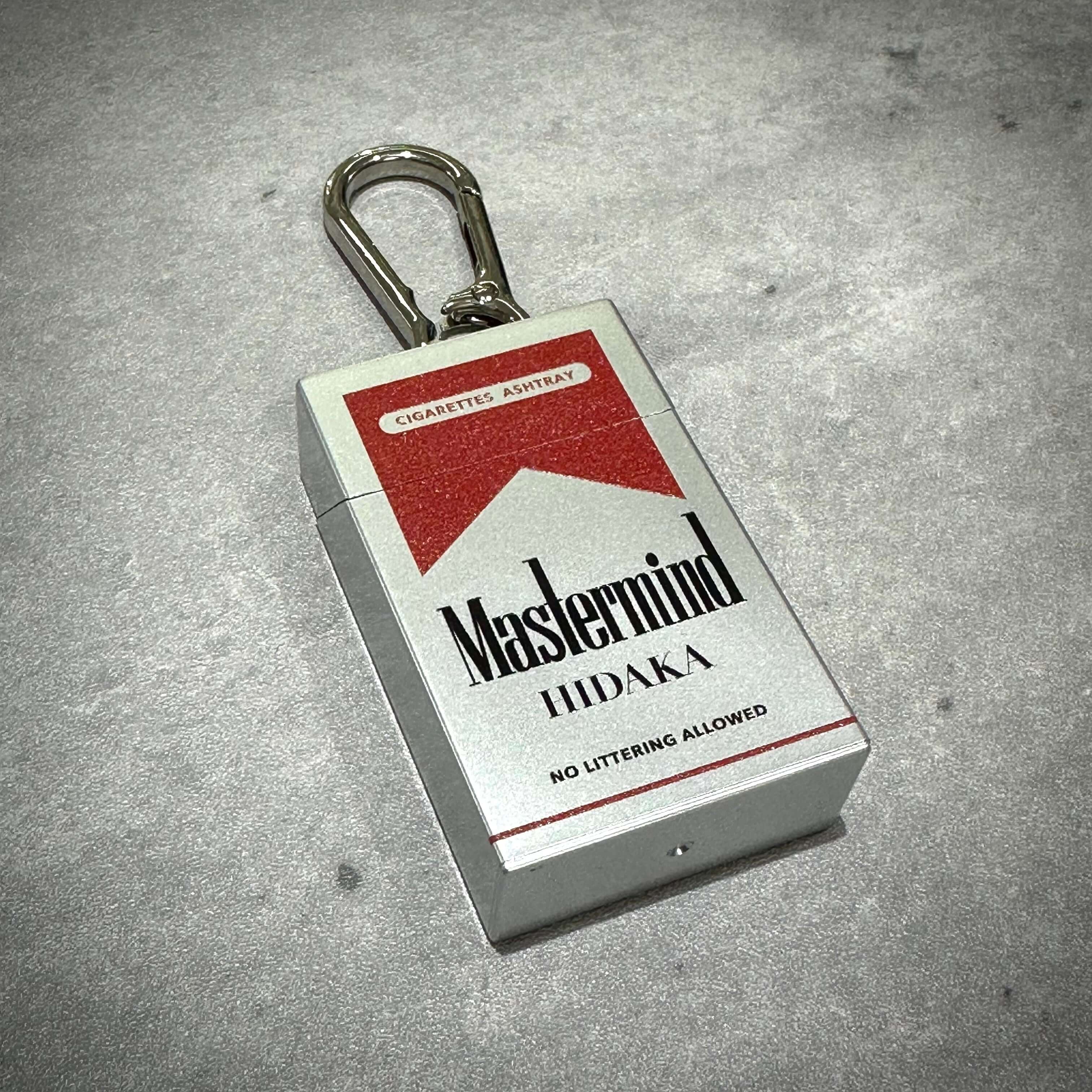 HIDAKA x mastermind JAPAN portable ashtray in red and silver with keychain, designed for convenience and style.