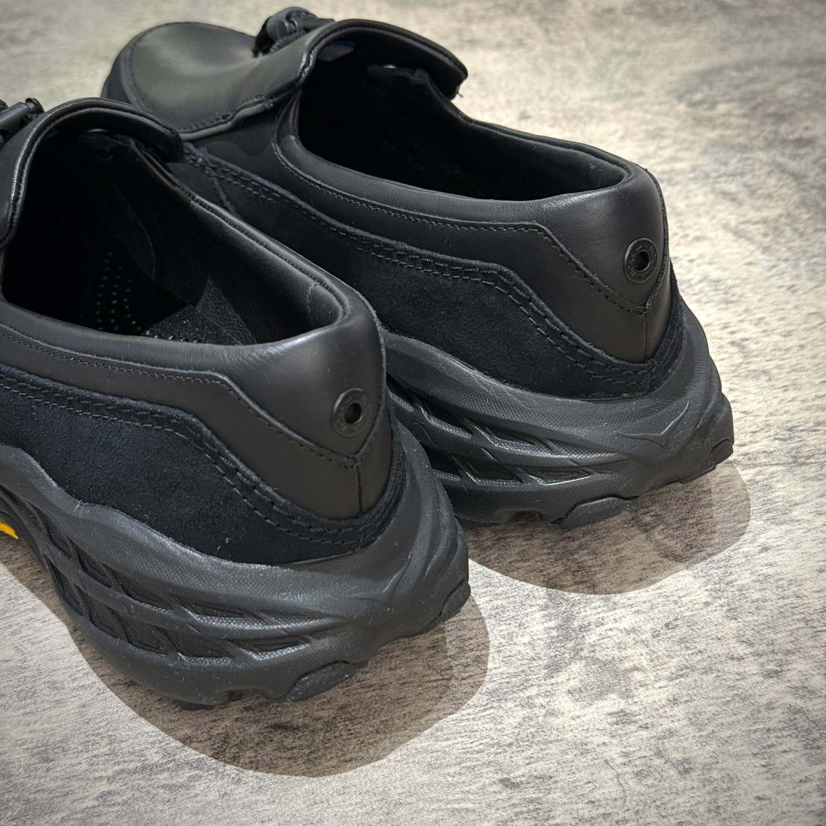 Hoka Speed Loafers - Black 1162170-BBLC showing the back view of the shoes highlighting their design and materials.