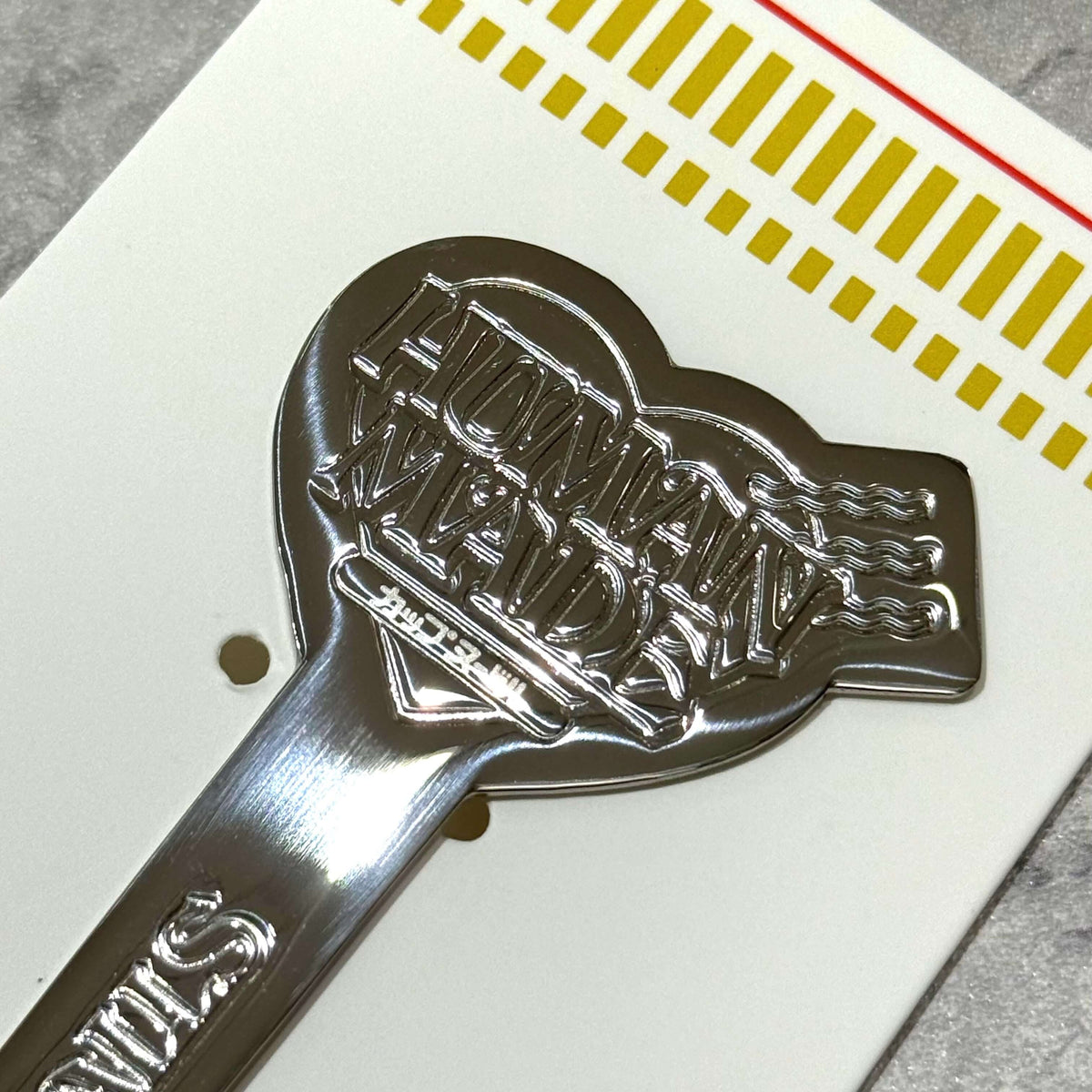 Close-up of the Human Made Cup Noodle Fork showcasing the logo and shiny design on a card.