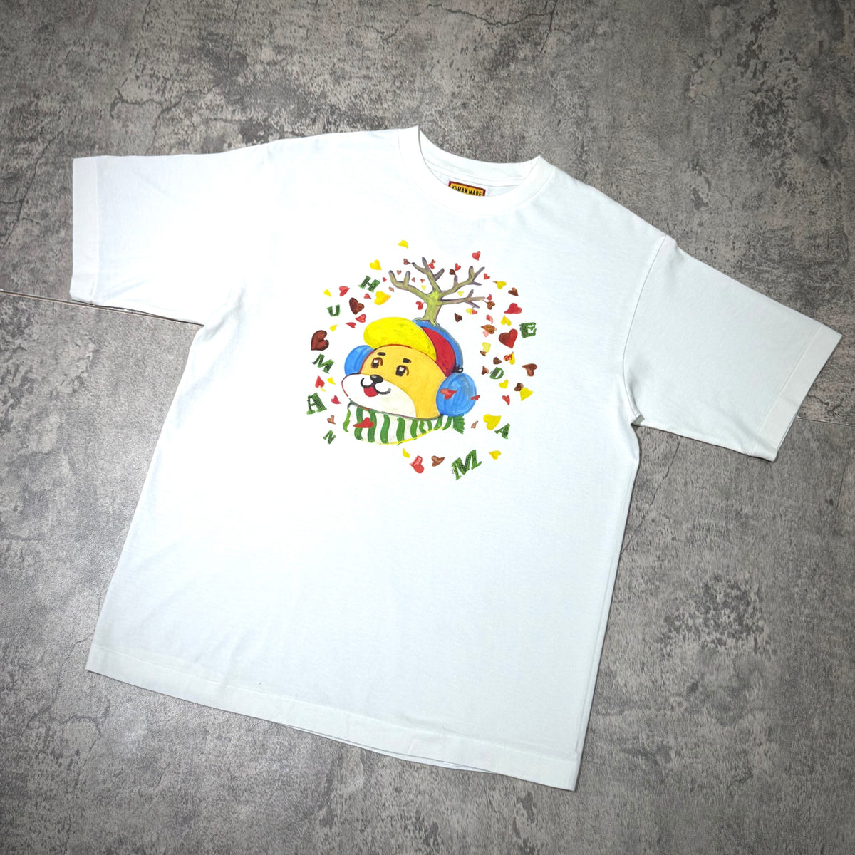 Human Made Keiko Sootome tee featuring colorful cartoon dog graphic on a white background.