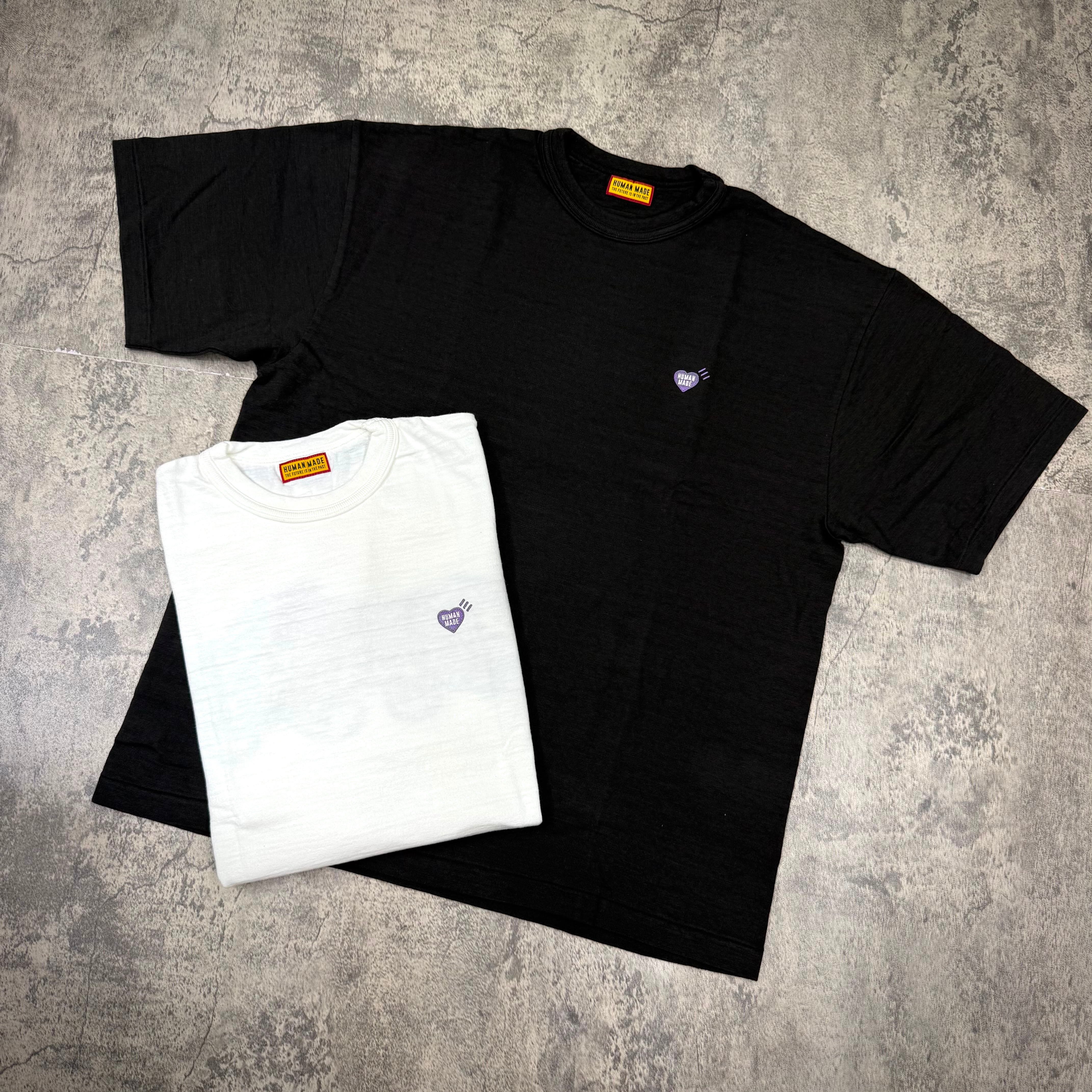 Human Made Apgujeong Exclusive Leopard Back Logo Tee in black and white displayed on a textured surface.
