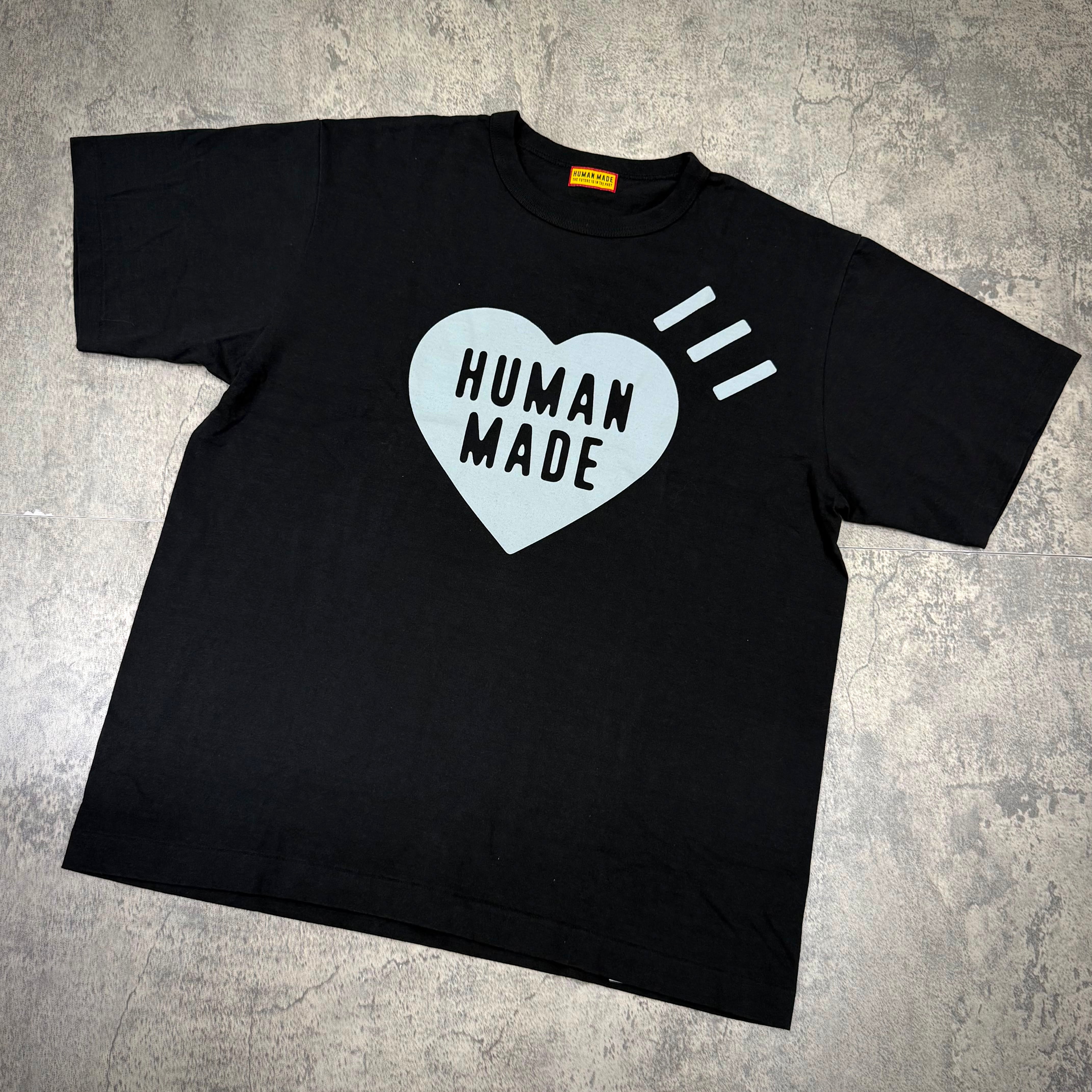 Human Made Sapporo Exclusive Heart Logo Tee displayed on a gray surface with heart-shaped logo design.