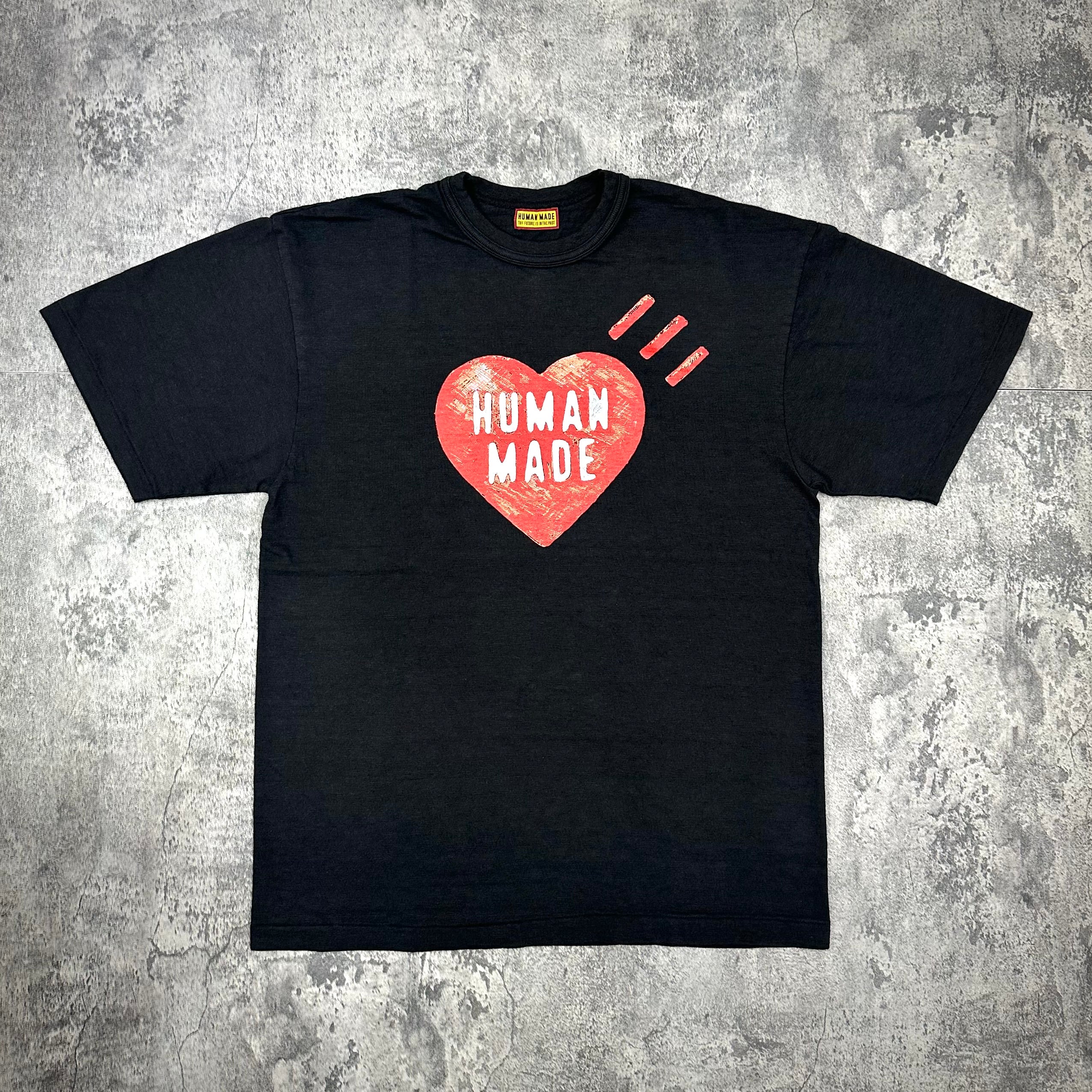 Human Made Heart Logo Tee FW25 in black featuring a heart design with text 'HUMAN MADE'.