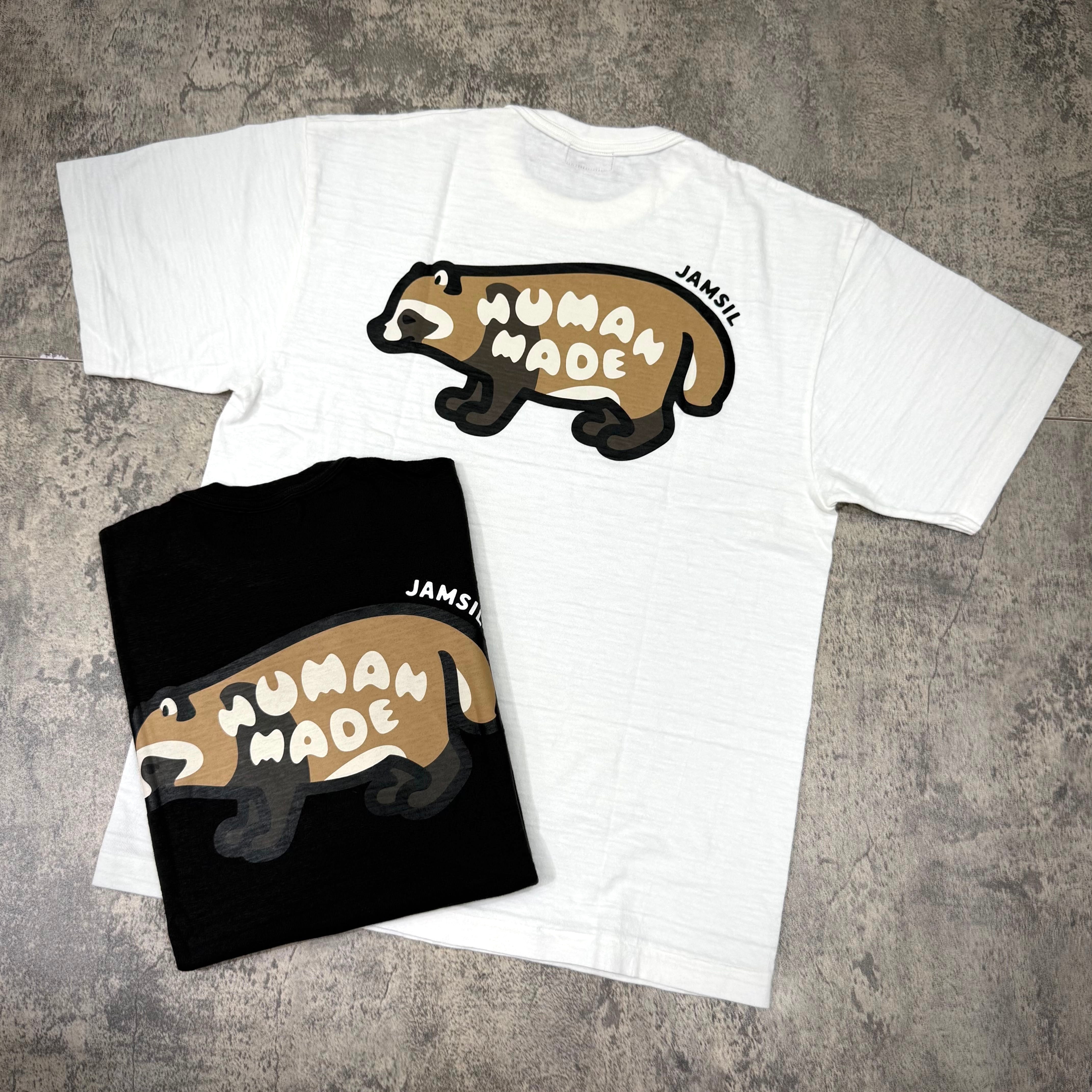 Human Made Jamsil Exclusive Raccon Back Logo Tee in white and black displayed on a textured surface.
