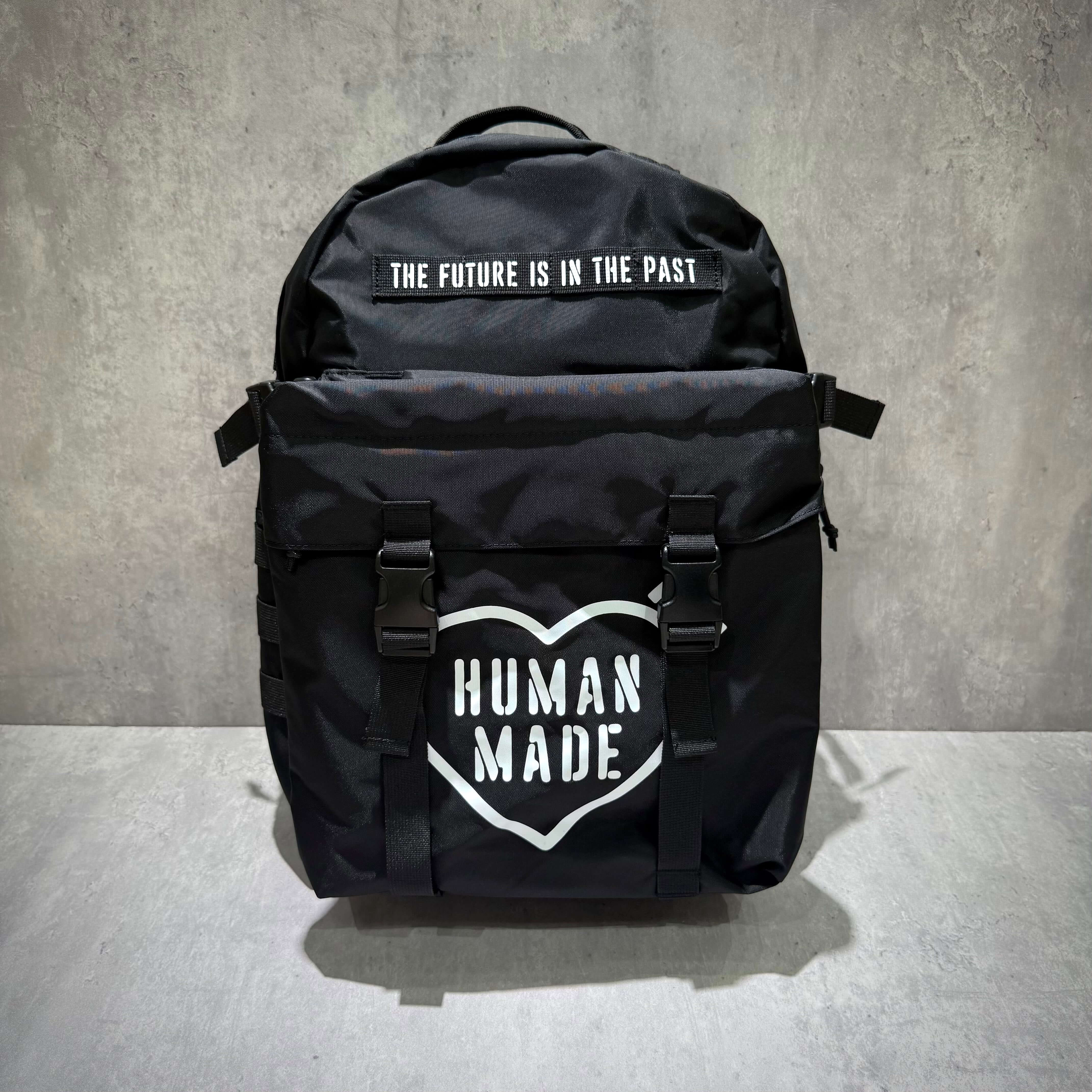 Human Made Military Backpack with statement logo and unique design on a gray background.