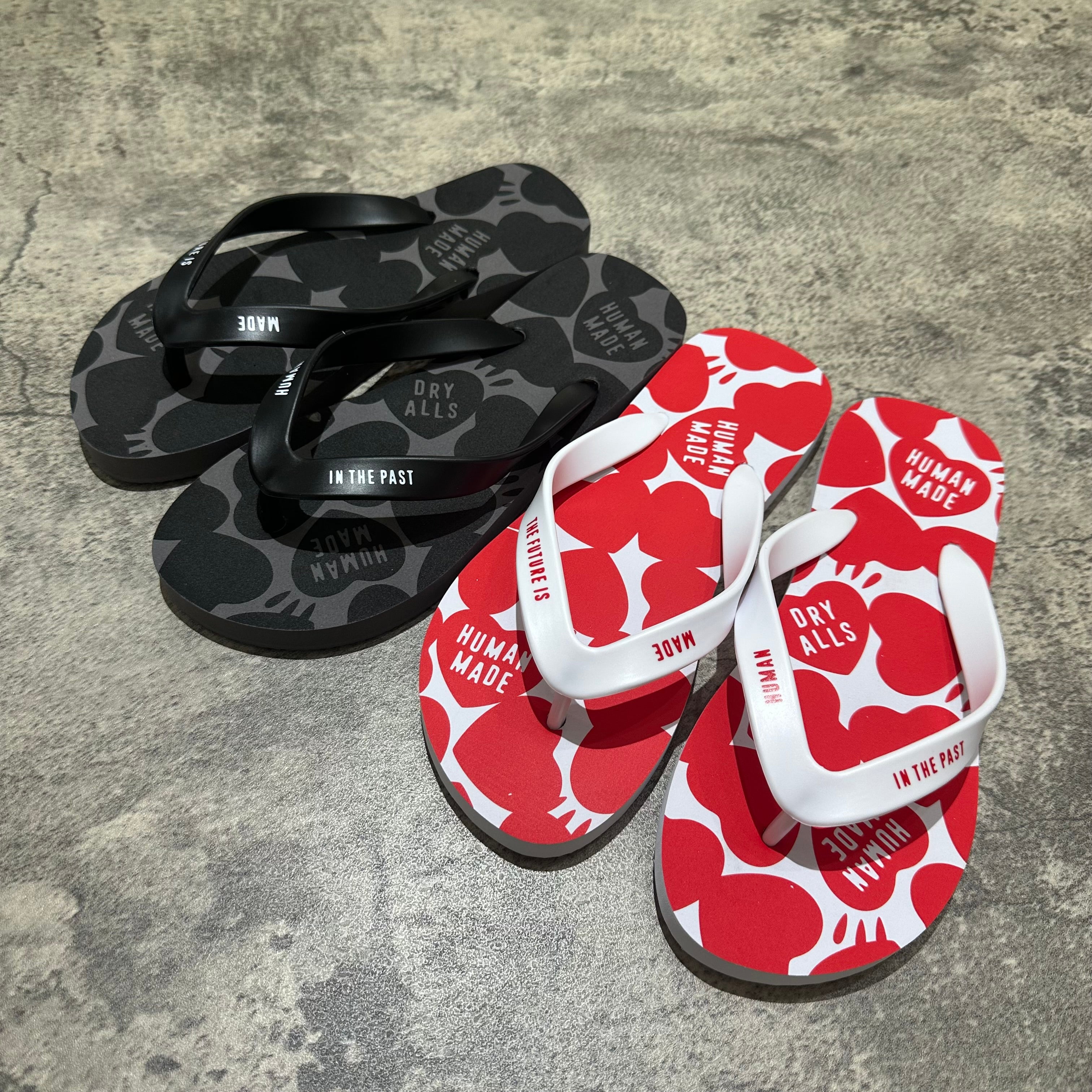 Human Made Sandal displayed in black and red colors, featuring unique graphic designs on flip flops.