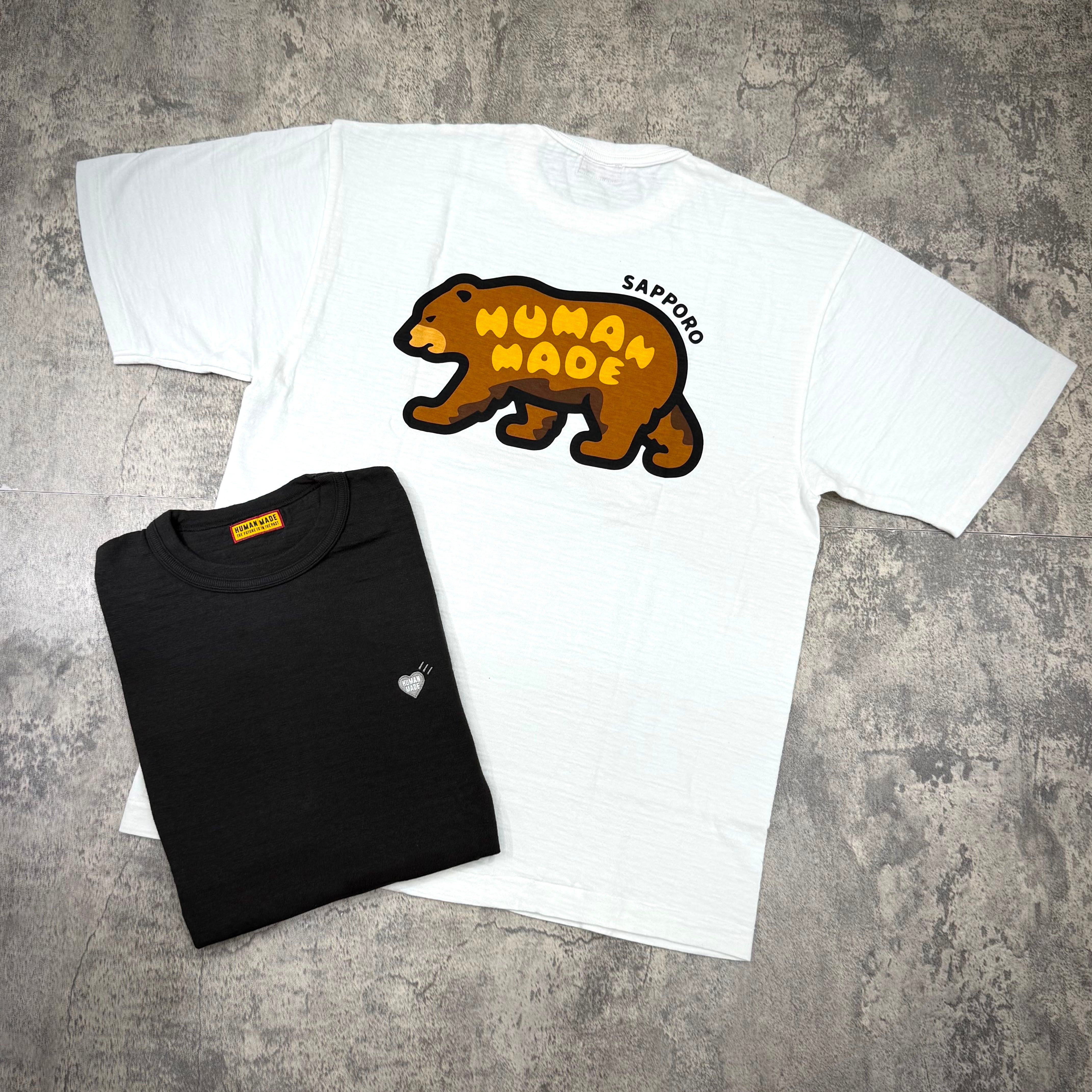 Human Made Sapporo Exclusive Bear Back Logo Tee displayed alongside a black tee, highlighting the bear logo design.
