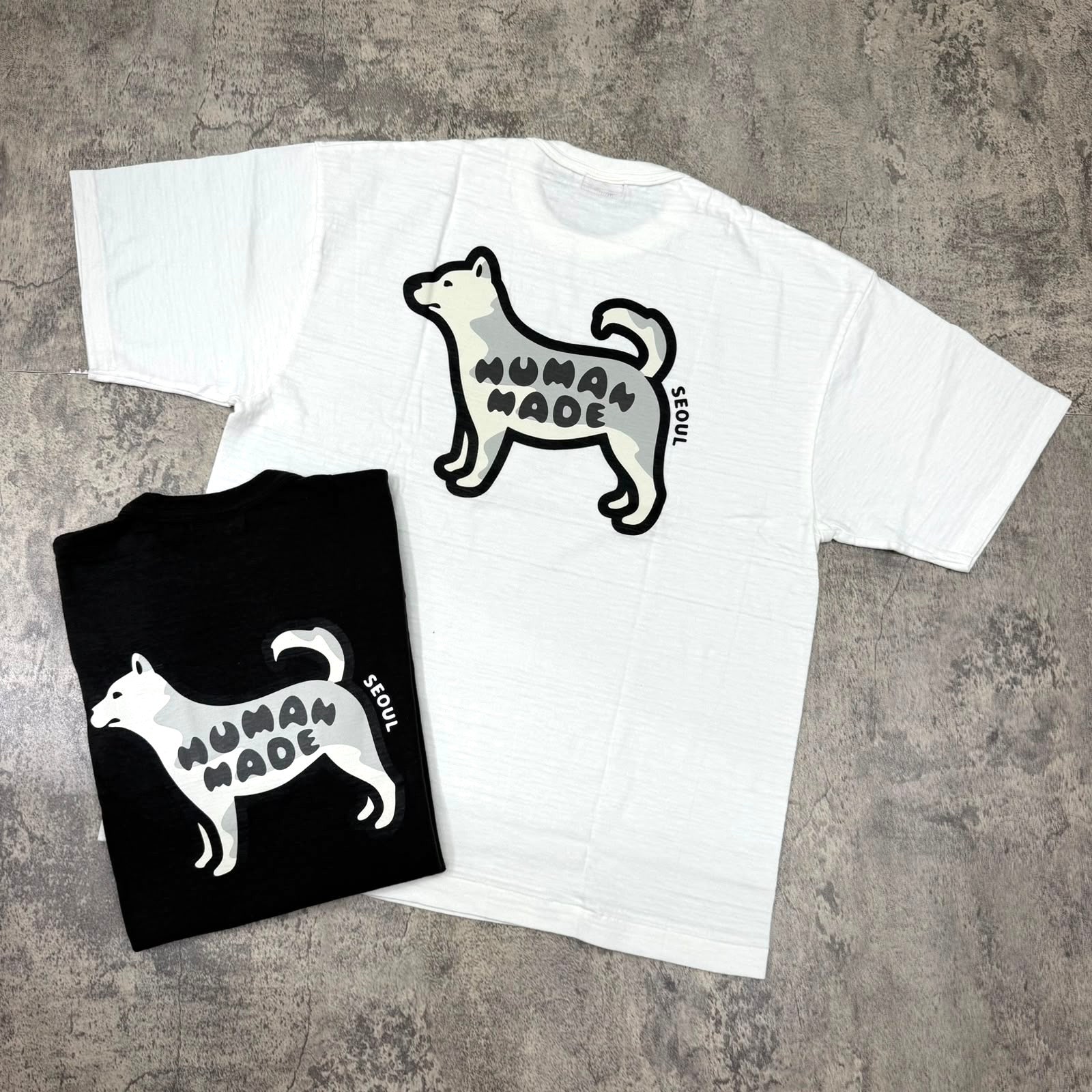 Human Made Seoul Exclusive Jindo Dog Back Logo Tee in black and white colors on a flat surface.