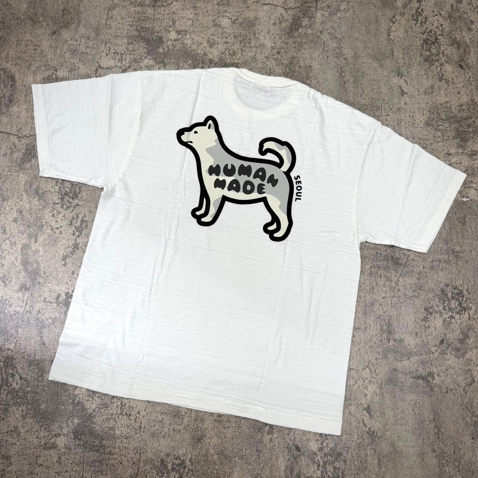 Human Made Seoul Exclusive Jindo Dog Back Logo Tee featuring a playful dog graphic in black on a white t-shirt.