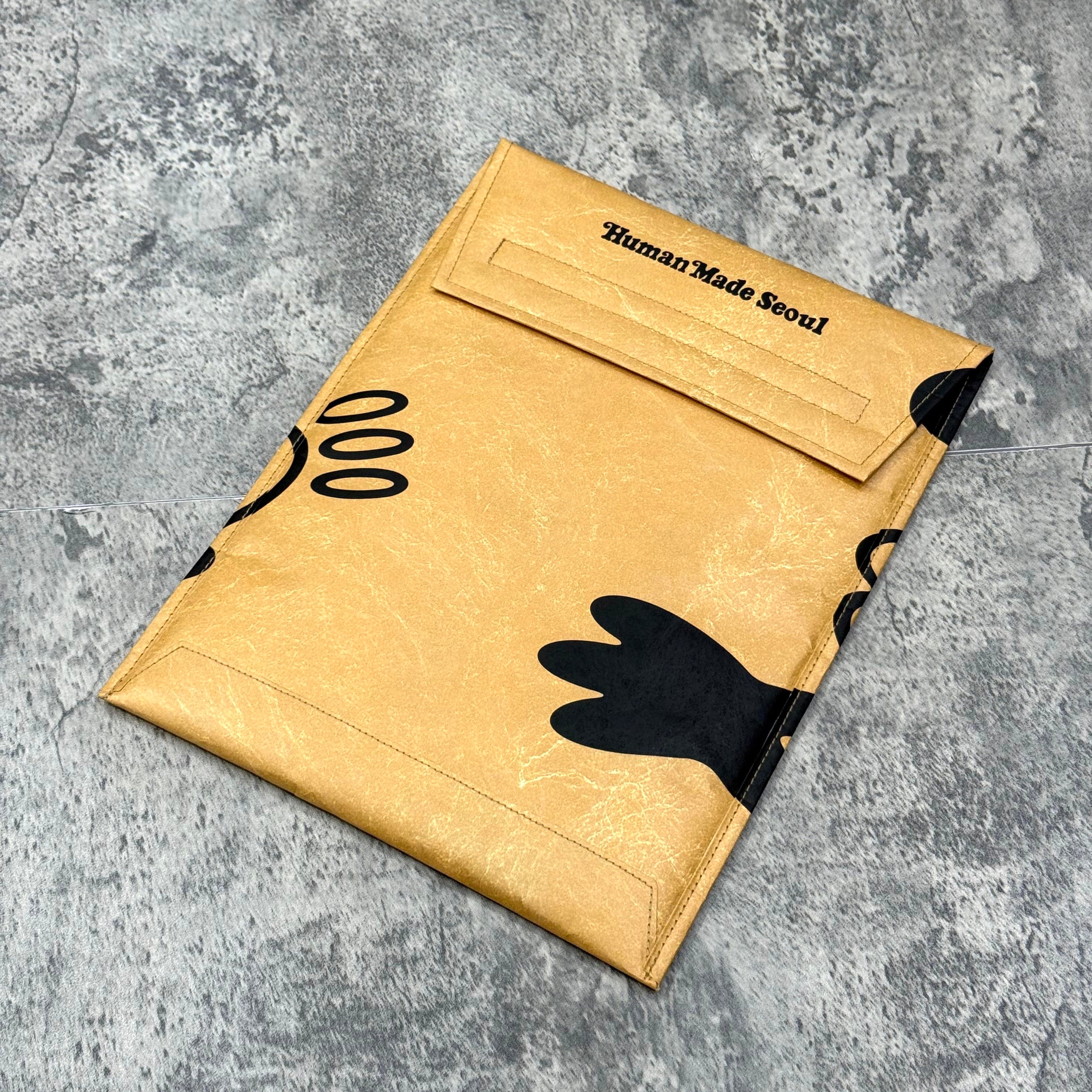 Human Made x VERDY Jamsil Exclusive Tablet Case in gold with black illustrations on a textured background.