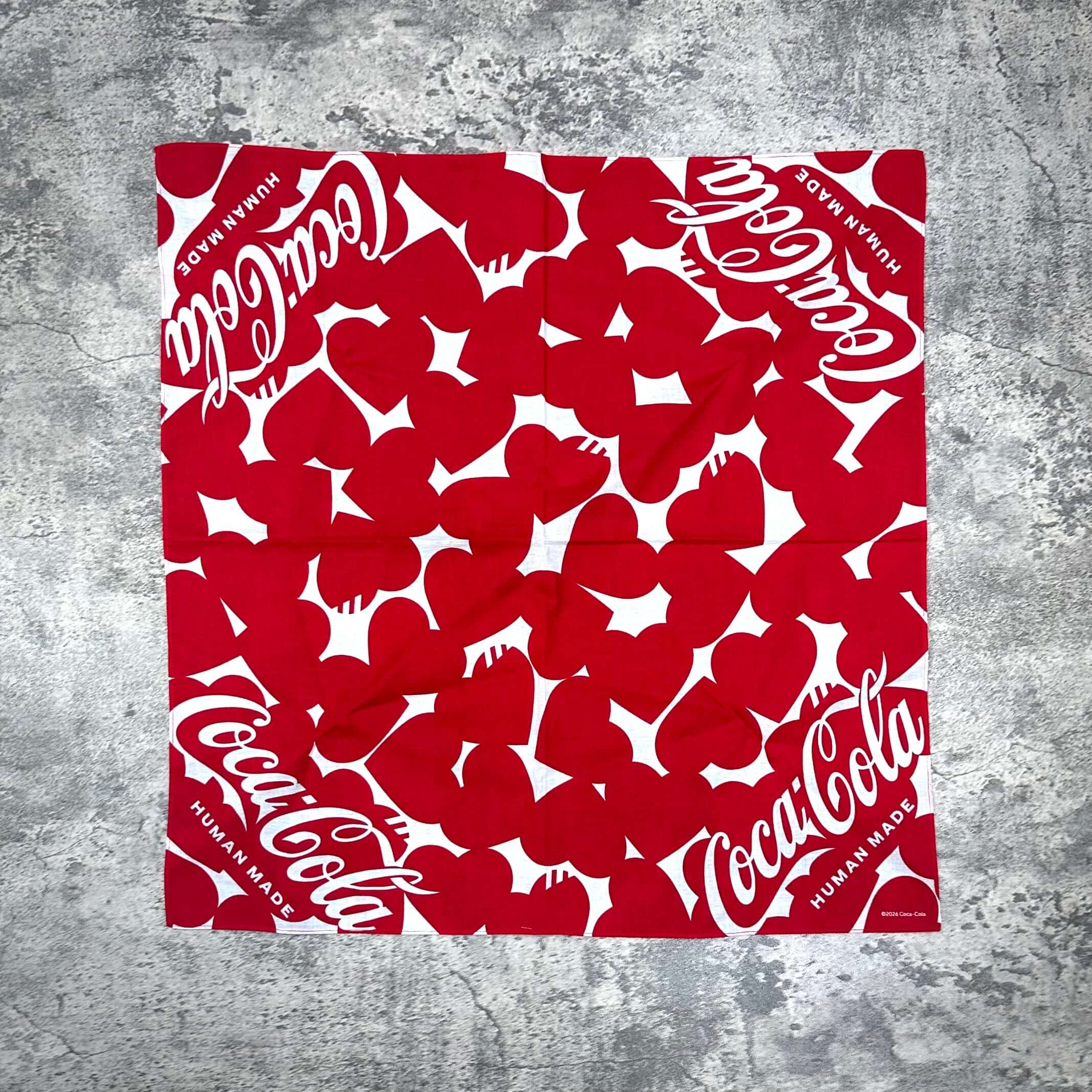 Human Made Coca Cola bandana featuring a red and white pattern with iconic Coca Cola logos.