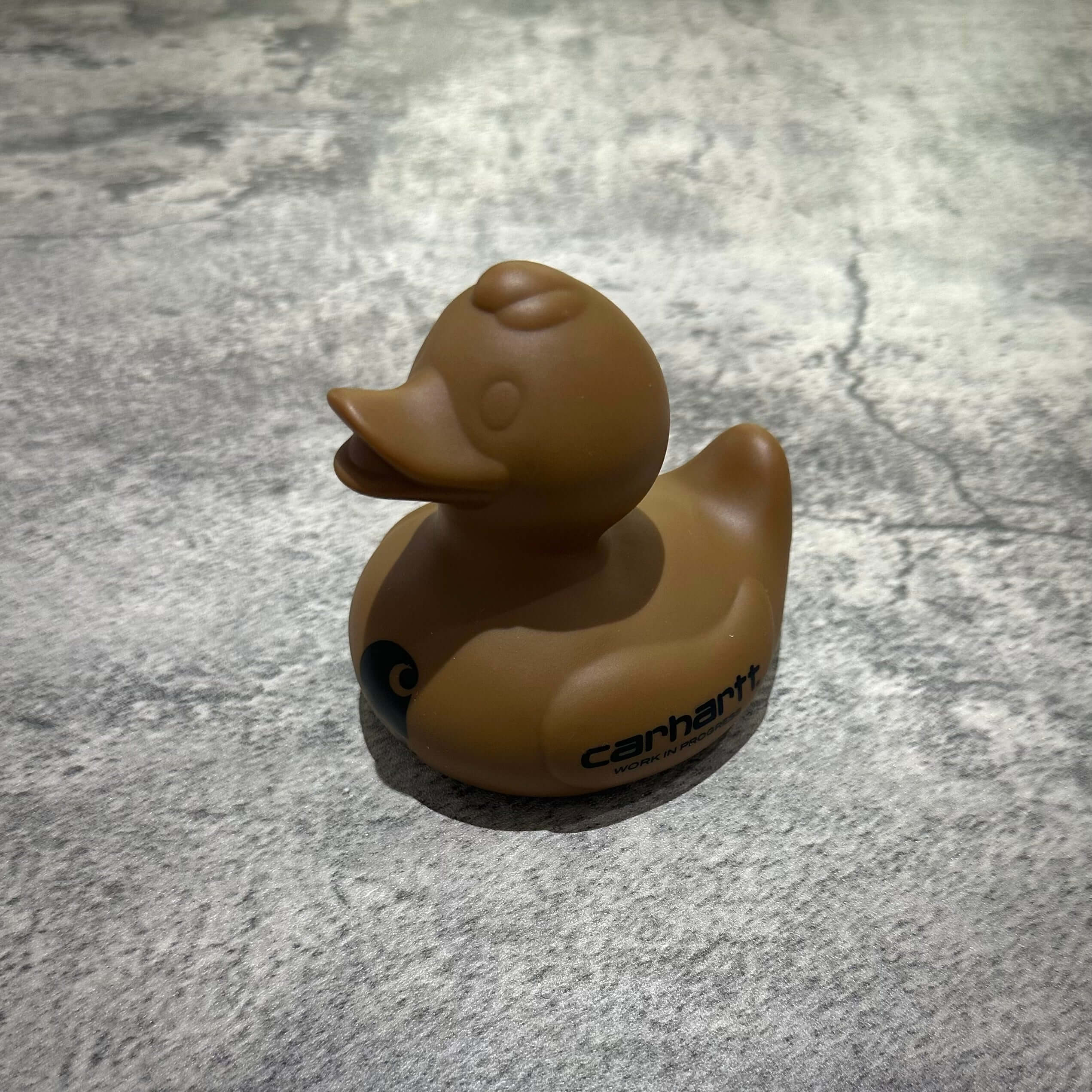 Carhartt WIP x FCRB Rubber Duck in brown color on textured surface