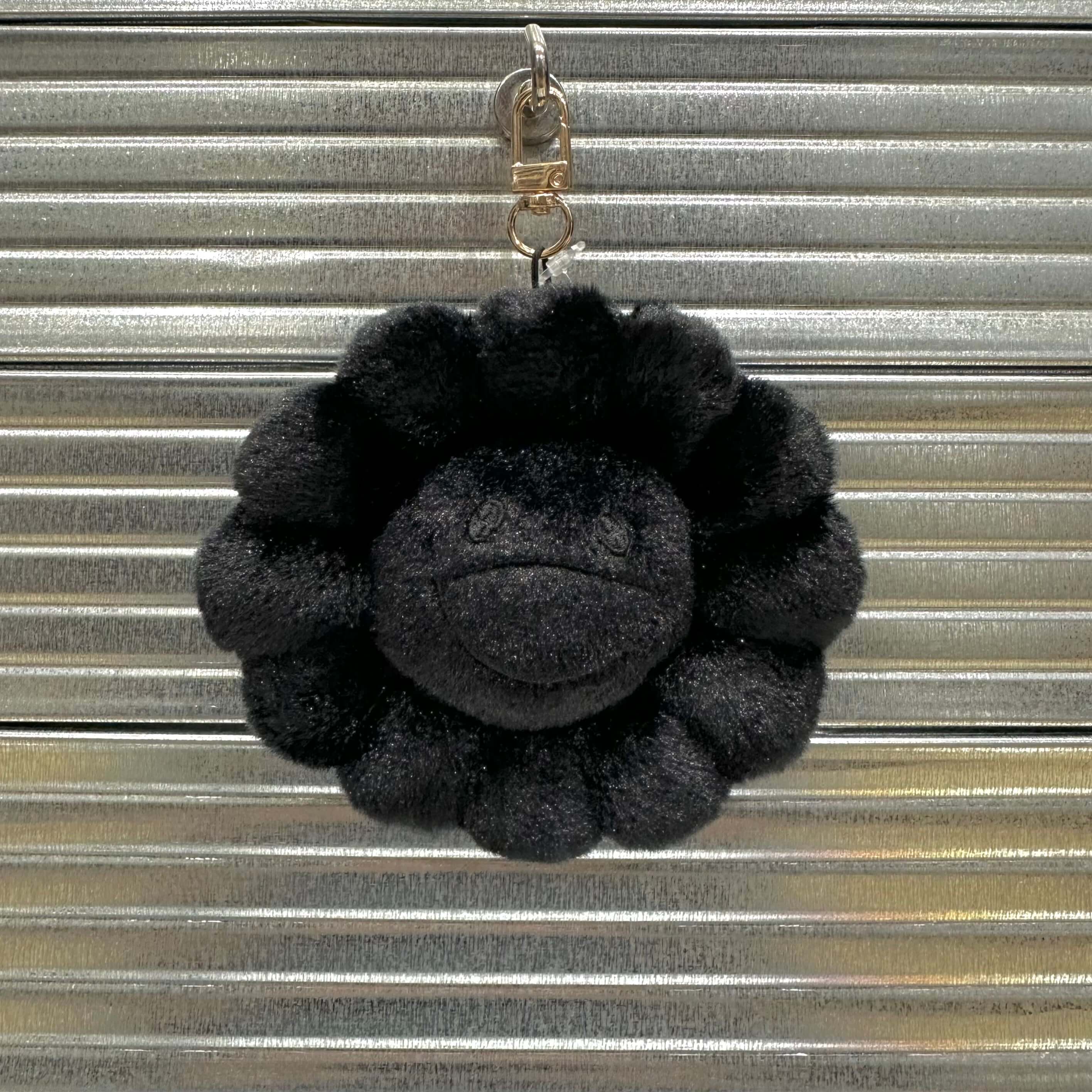 Takashi Murakami Mascot Plush Keychain in black, featuring a textured round design and metal clip for easy attachment.