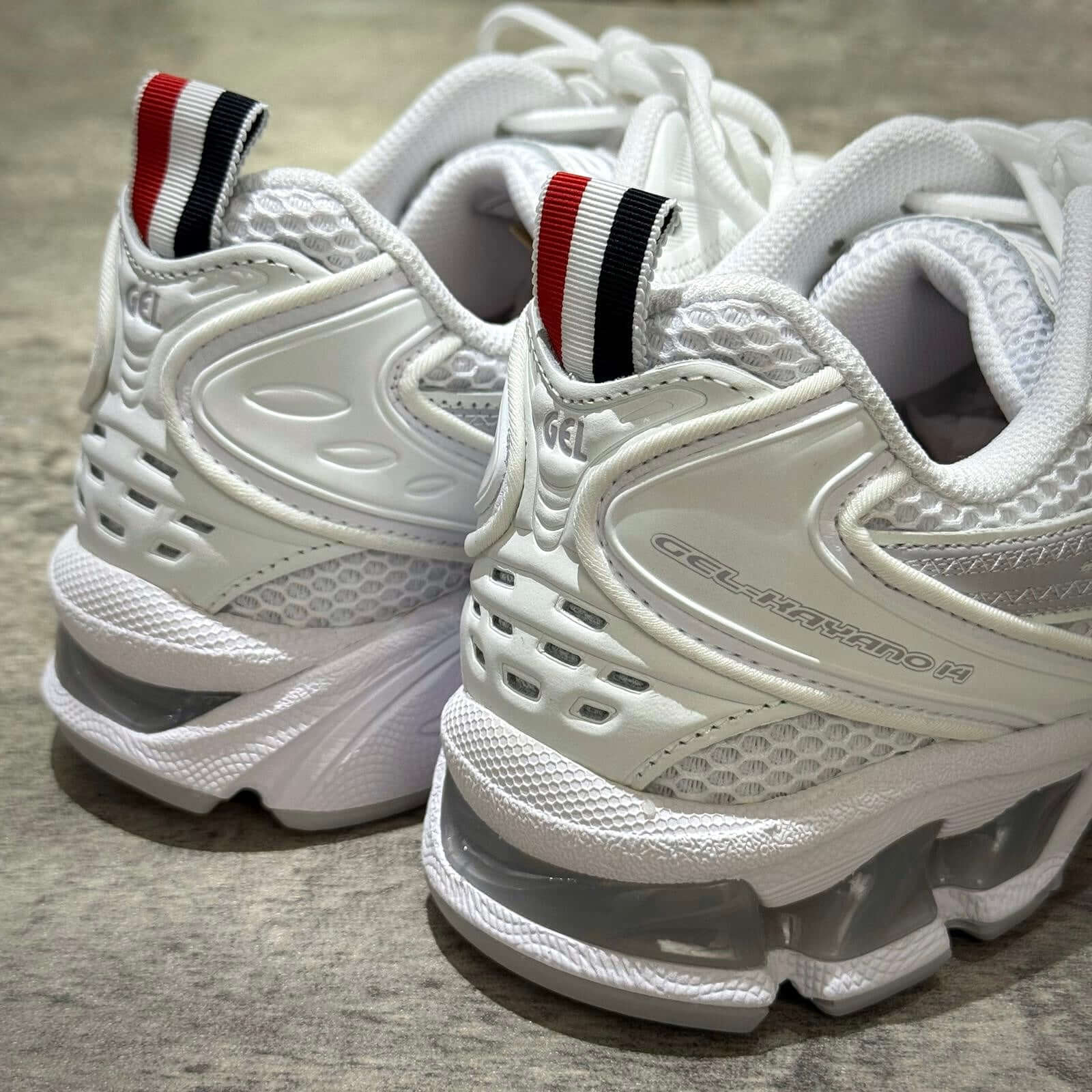Thom Browne x Asics Gel-Kayano 14 - White sneaker detail showing heel and logo.
