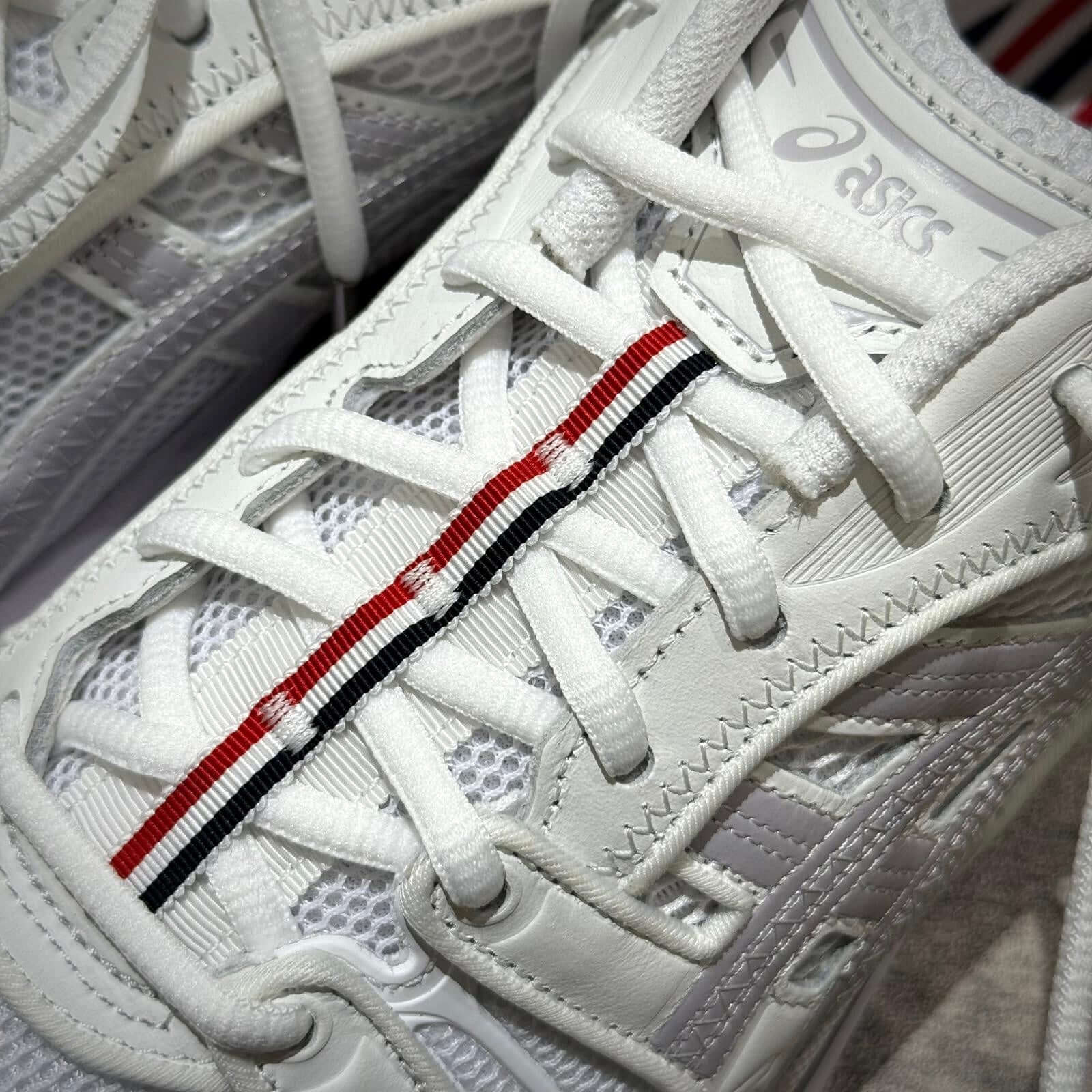 Thom Browne x Asics Gel-Kayano 14 white sneaker laces with distinctive red and black stripe detail.