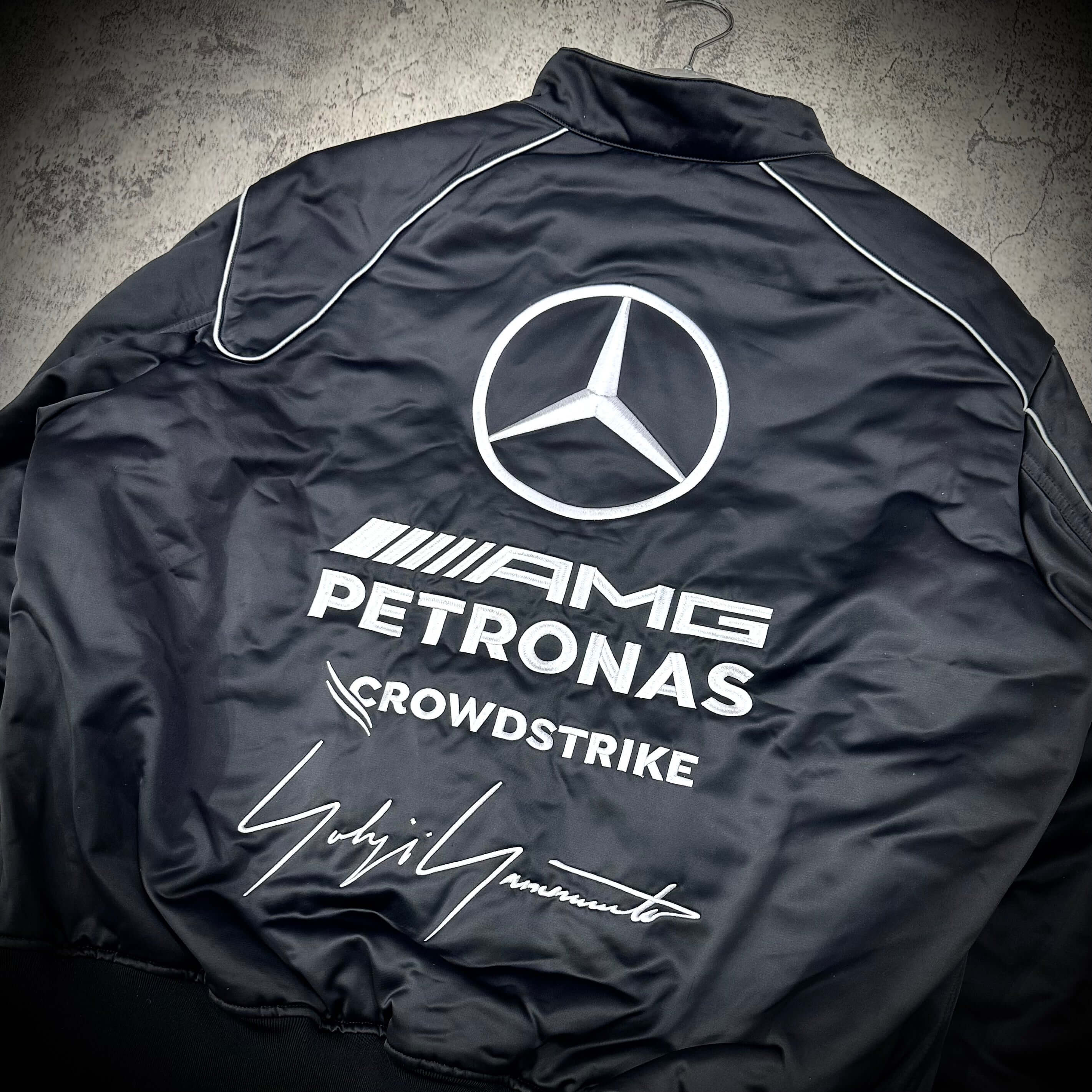 Back view of Y-3 x Mercedes AMG Petronas F1 Team Jacket featuring logos and signature design.