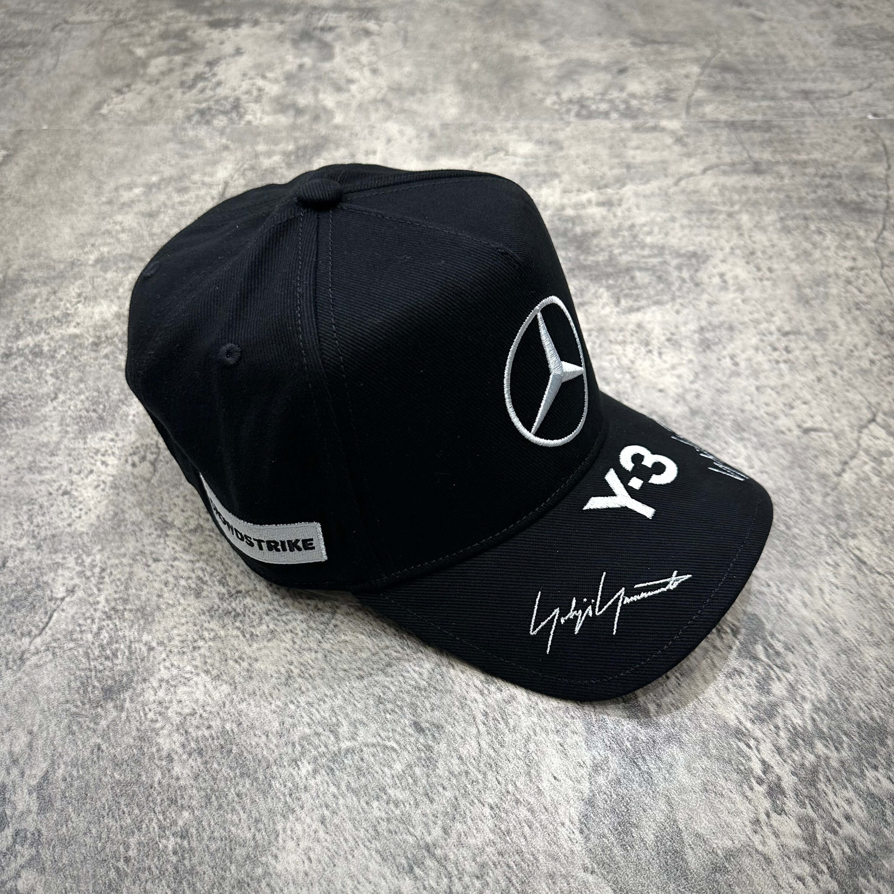 Y-3 x Mercedes AMG Petronas F1 podium cap in black and grey with signature detail.