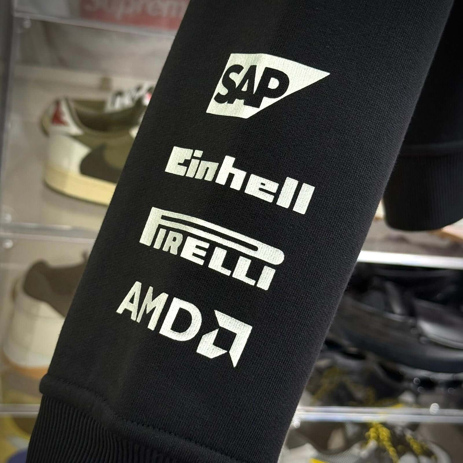 Logo details on the arm of the Y-3 x Mercedes AMG Petronas F1 Hoodie featuring SAP, Einhell, Pirelli, and AMD.
