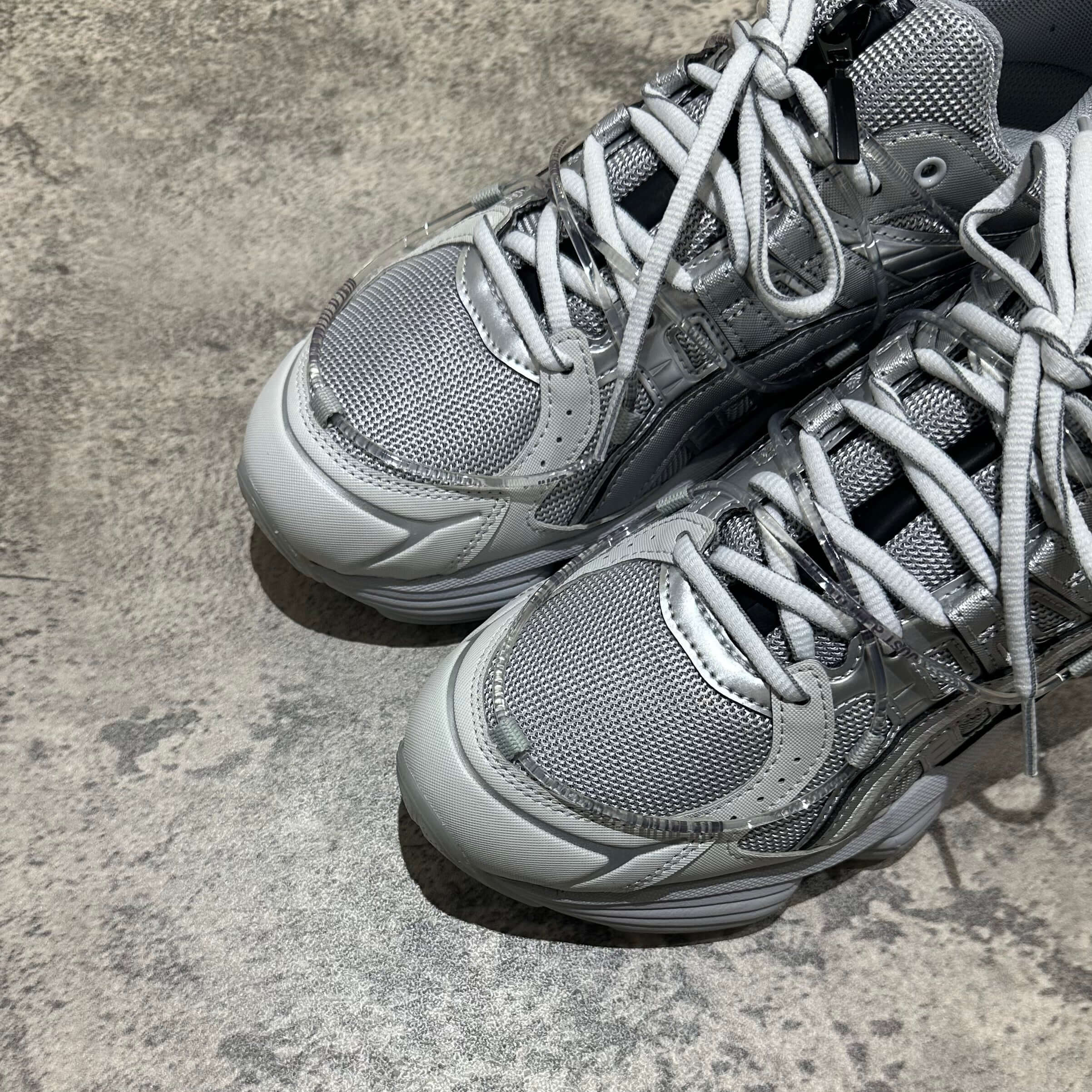 Close-up of Yoasobi x Asics Gel Kinetic Fluent Y sneakers in Piedmont Grey and Pure Silver.