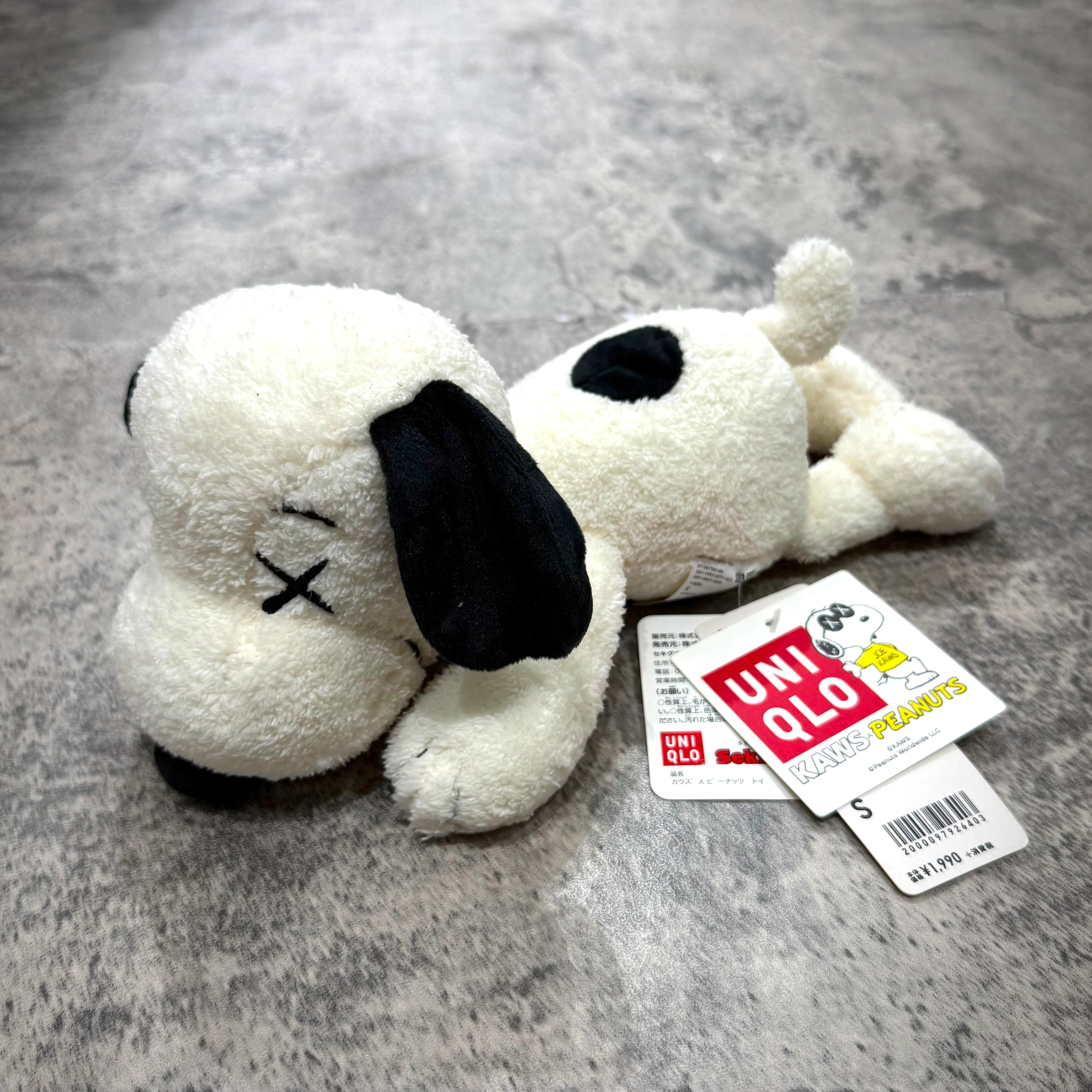 KAWS x Uniqlo x Peanuts Snoopy Plush (Small) - White with red collar, black ears, and signature "X" eyes.