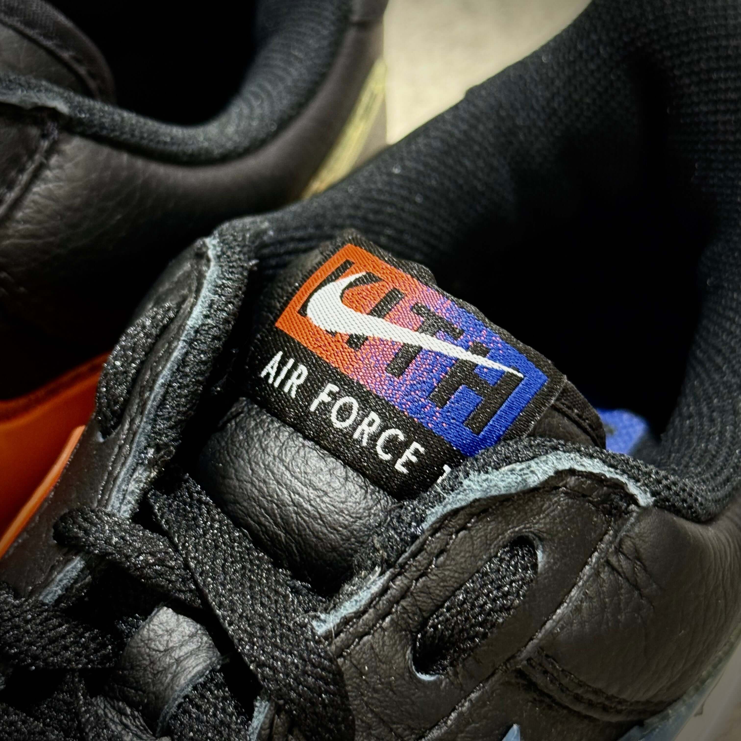 Close-up of the KITH x Nike Air Force 1 Low Knicks sneaker showing branding details.