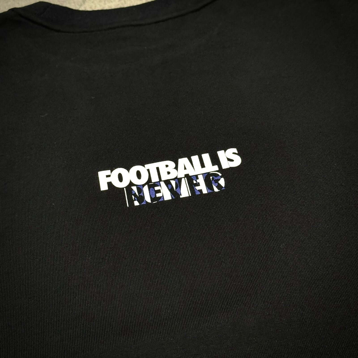 Kojiro Hyuga x F.C.Real Bristol Emblem Tee featuring 'Football is Never' graphic on a black shirt.