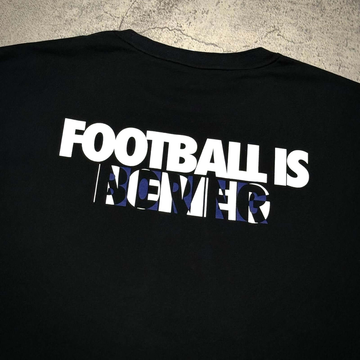 Kojiro Hyuga x F.C.Real Bristol On The Front Baggy Tee with bold 'Football is Forever' graphic on black fabric.