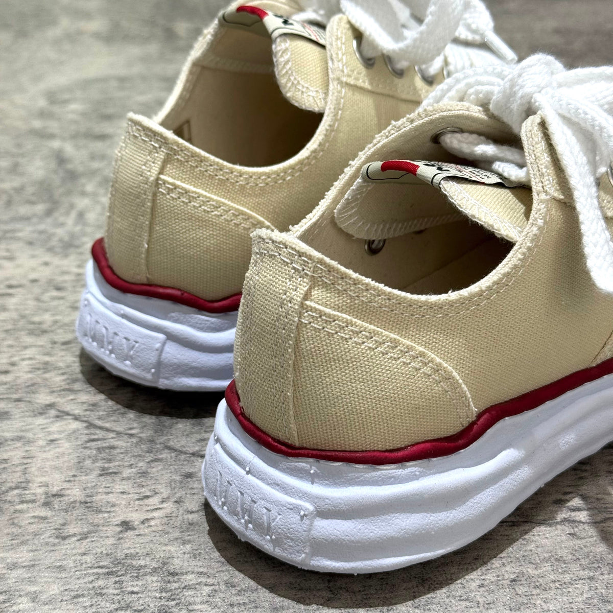 Close-up of MMY PETERSON OG Canvas - Natural shoes showcasing beige canvas and red accents.