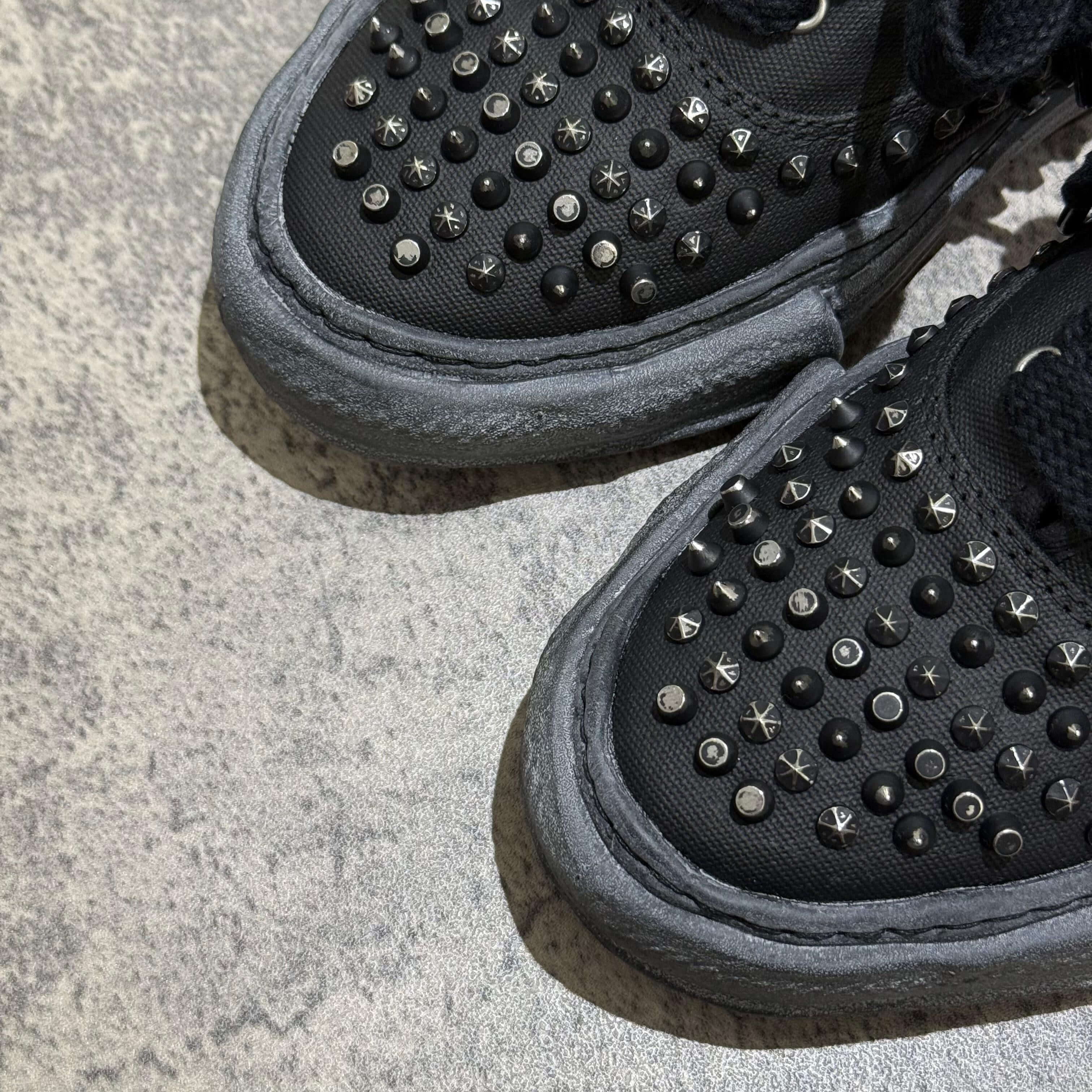 MMY Baker Studded Canvas Low - All Black close-up showing textured studded design on black canvas sneakers.
