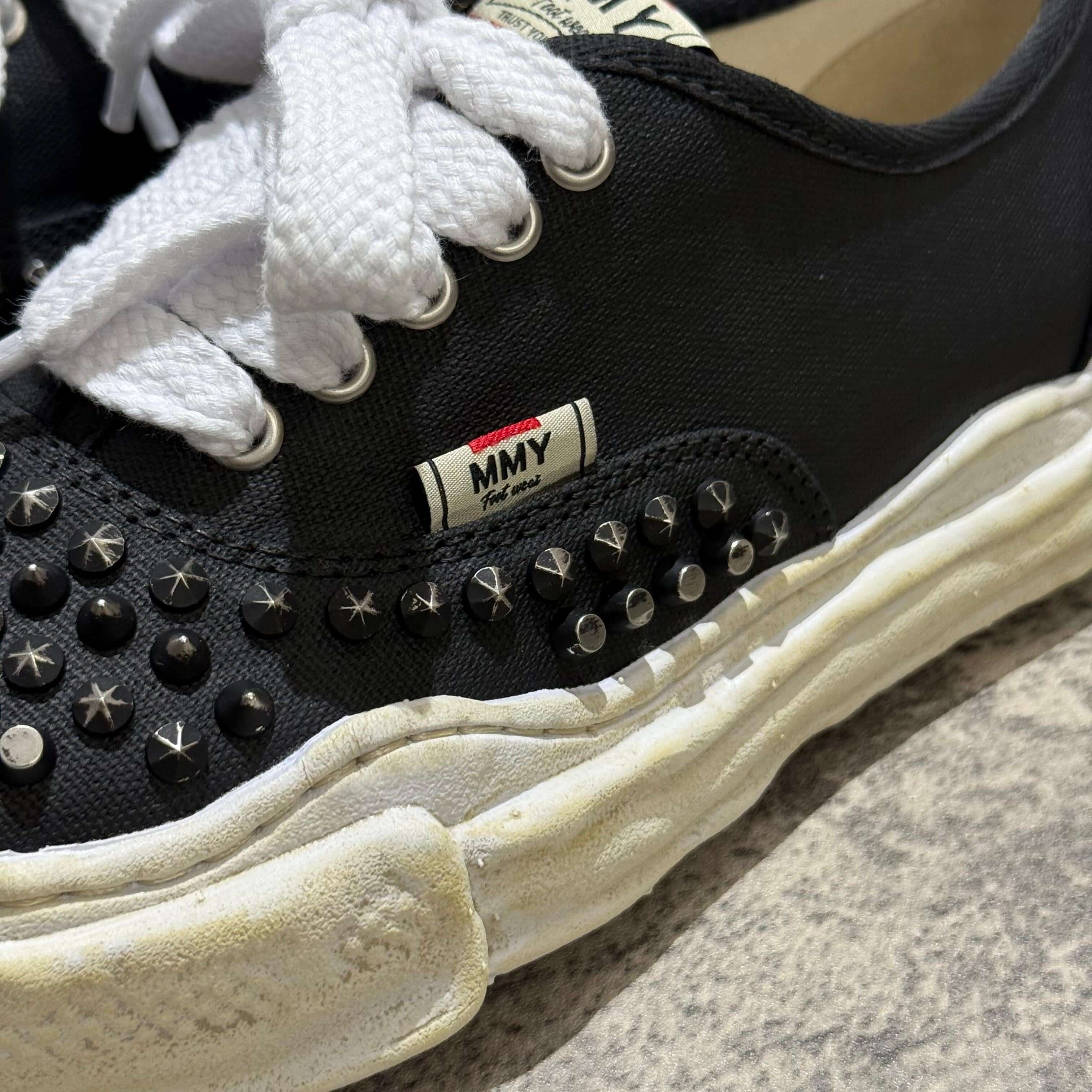 Close-up of MMY Baker Studded Canvas Low in Black/White with studs and white laces.