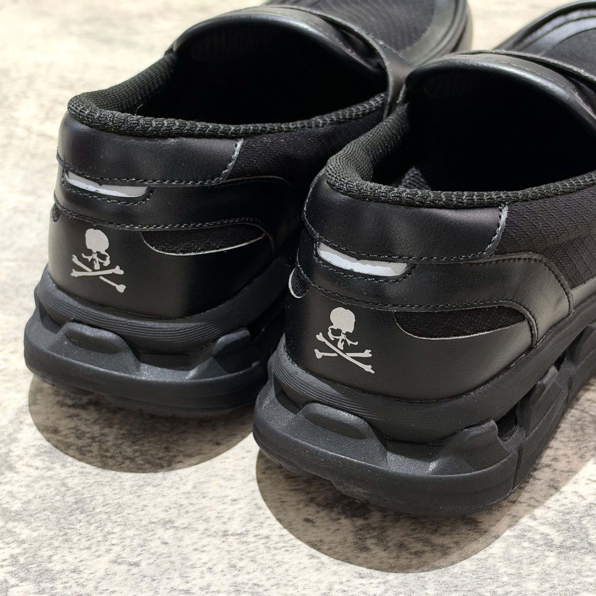 Mastermind World x Moisthrough 360 Hobalips black sneakers featuring skull and crossbones logo on the heel.
