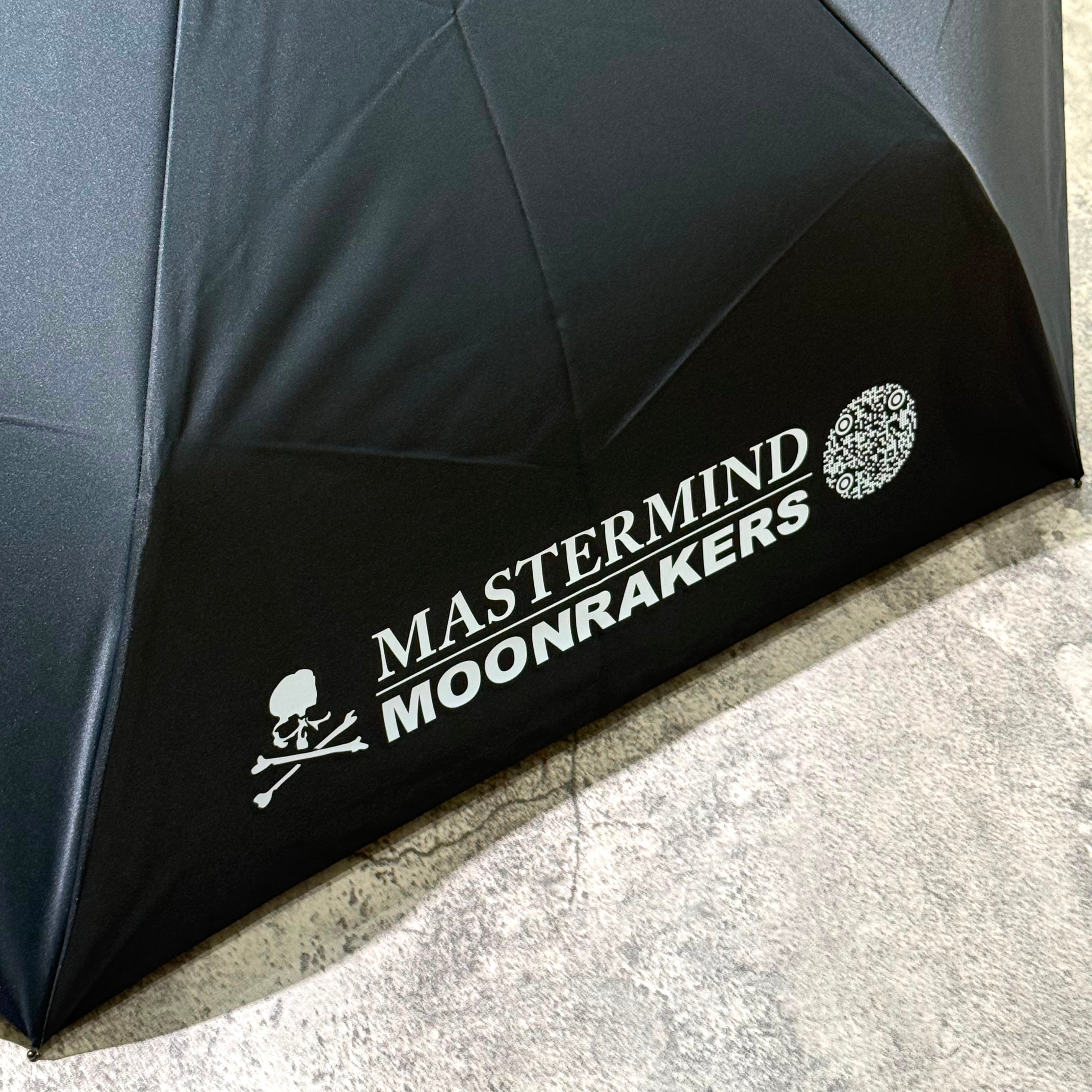 Mastermind Japan Moonrakers Umbrella displaying logo and design details on a black canopy.