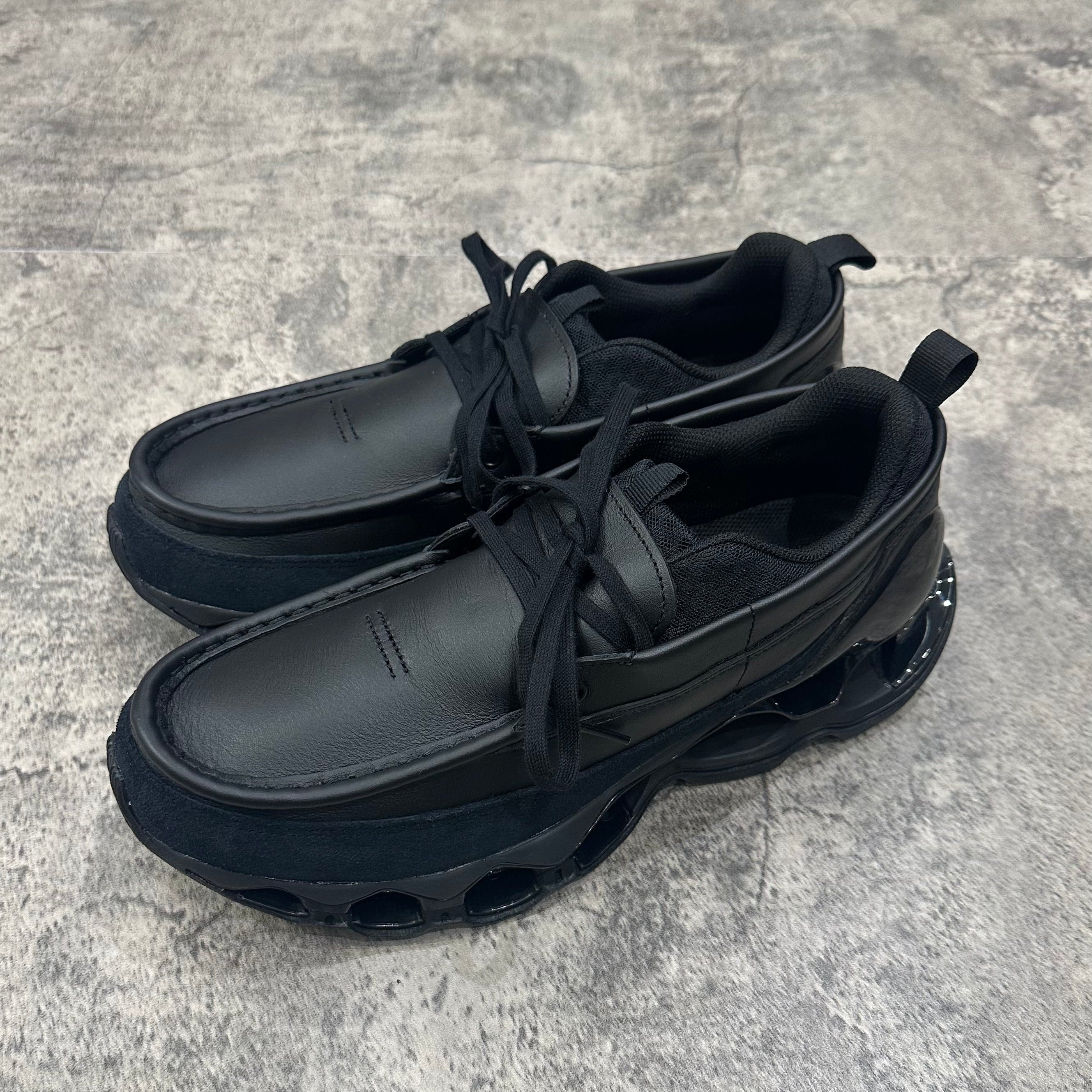 Mizuno Wave Prophecy Moc 2026 in all black color with thick sole and laces, perfect for athletic endeavors.