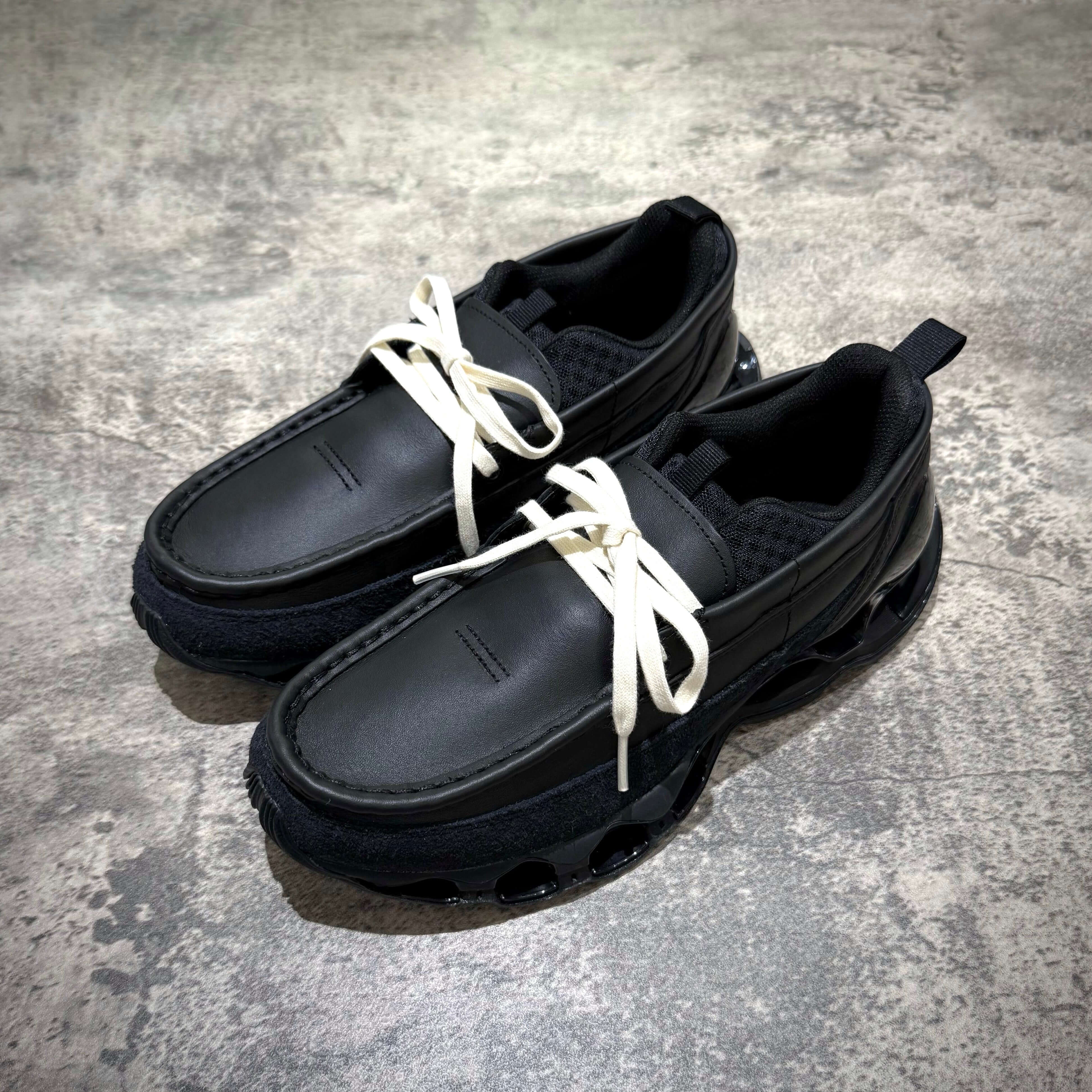 Mizuno Wave Prophecy Moc - Black shoes with white laces on a textured surface.