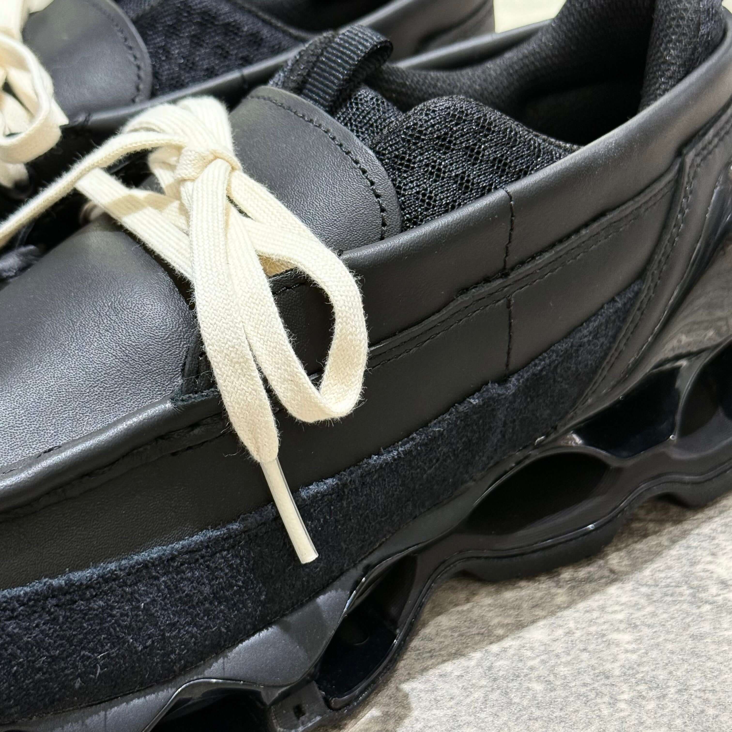 Close-up of Mizuno Wave Prophecy Moc - Black showing details of the upper, laces, and cushioning.