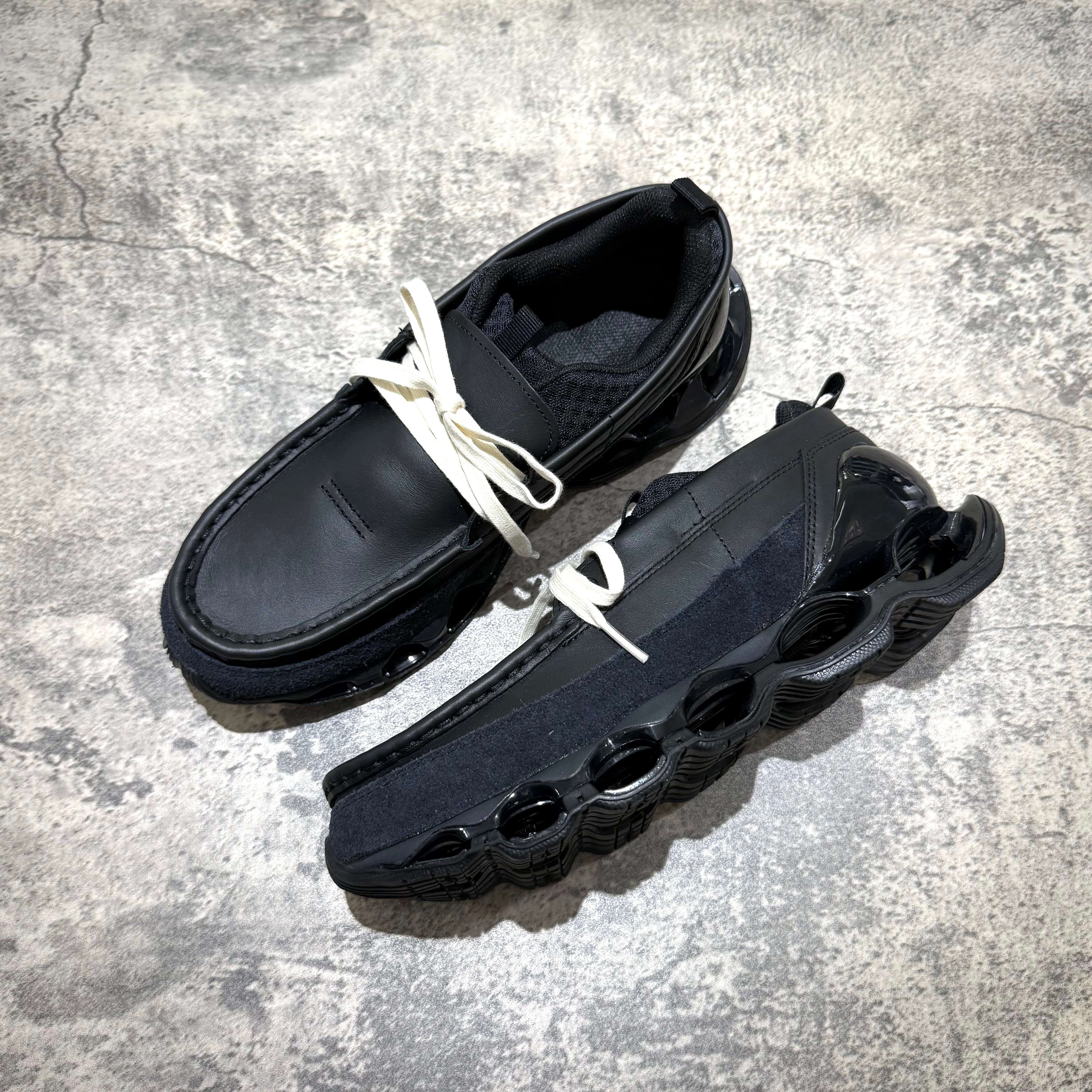 Mizuno Wave Prophecy Moc - Black shoes with unique design and laces on a textured surface.