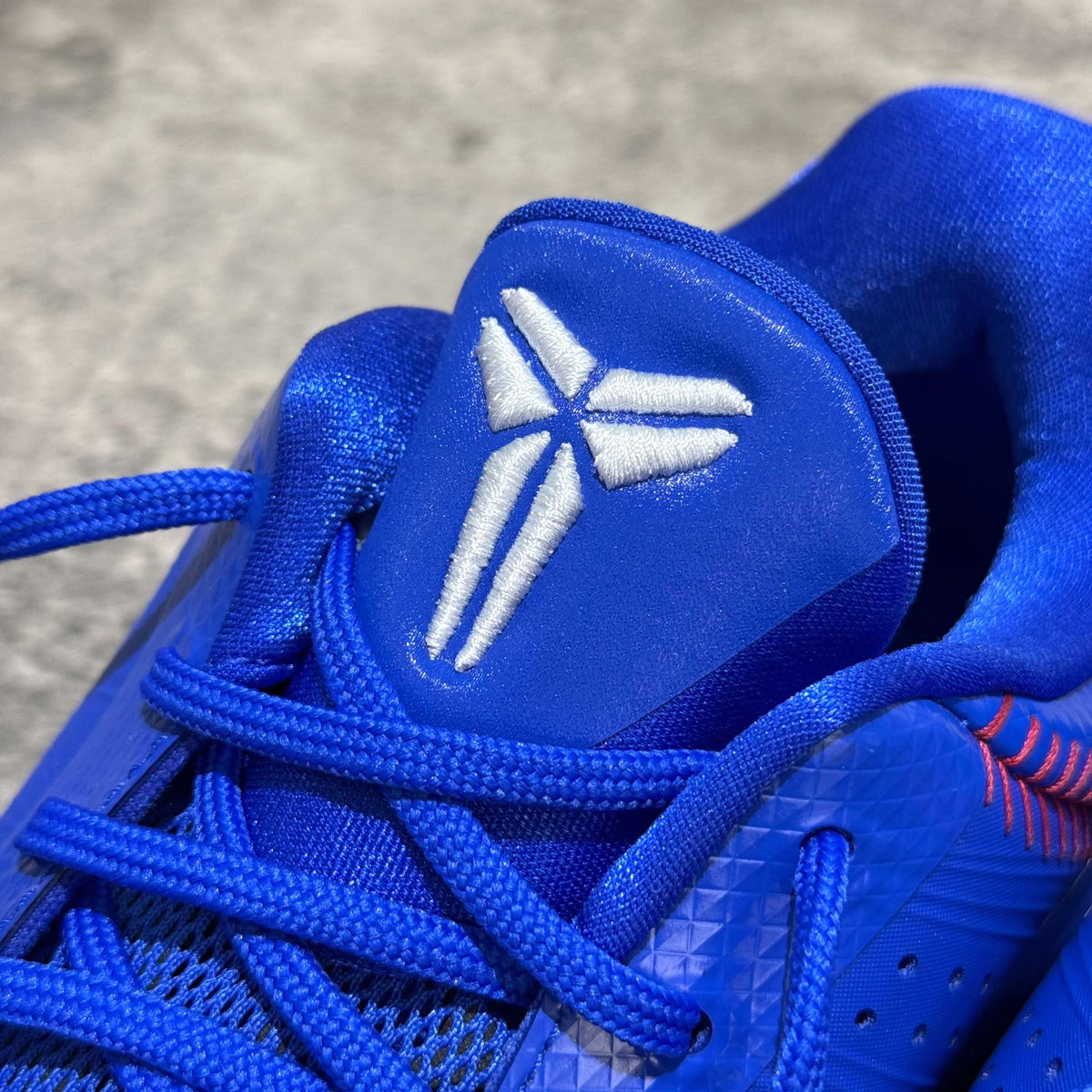Close-up of Nike Zoom Kobe 5 Protro Dodgers logo and laces in blue color.
