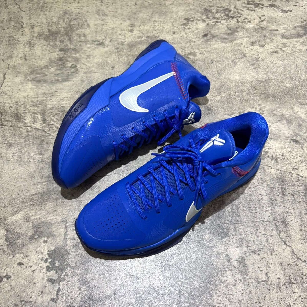 Nike Zoom Kobe 5 Protro Dodgers IO6256-400 sneakers in vibrant blue with white accents on a textured surface.