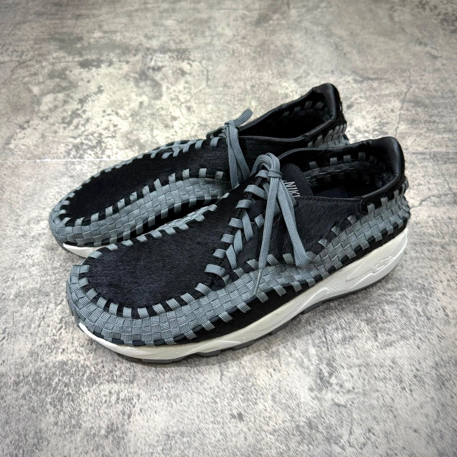 Nike Air Footscape Woven Black Smoke Grey shoe with braided design and grey accents