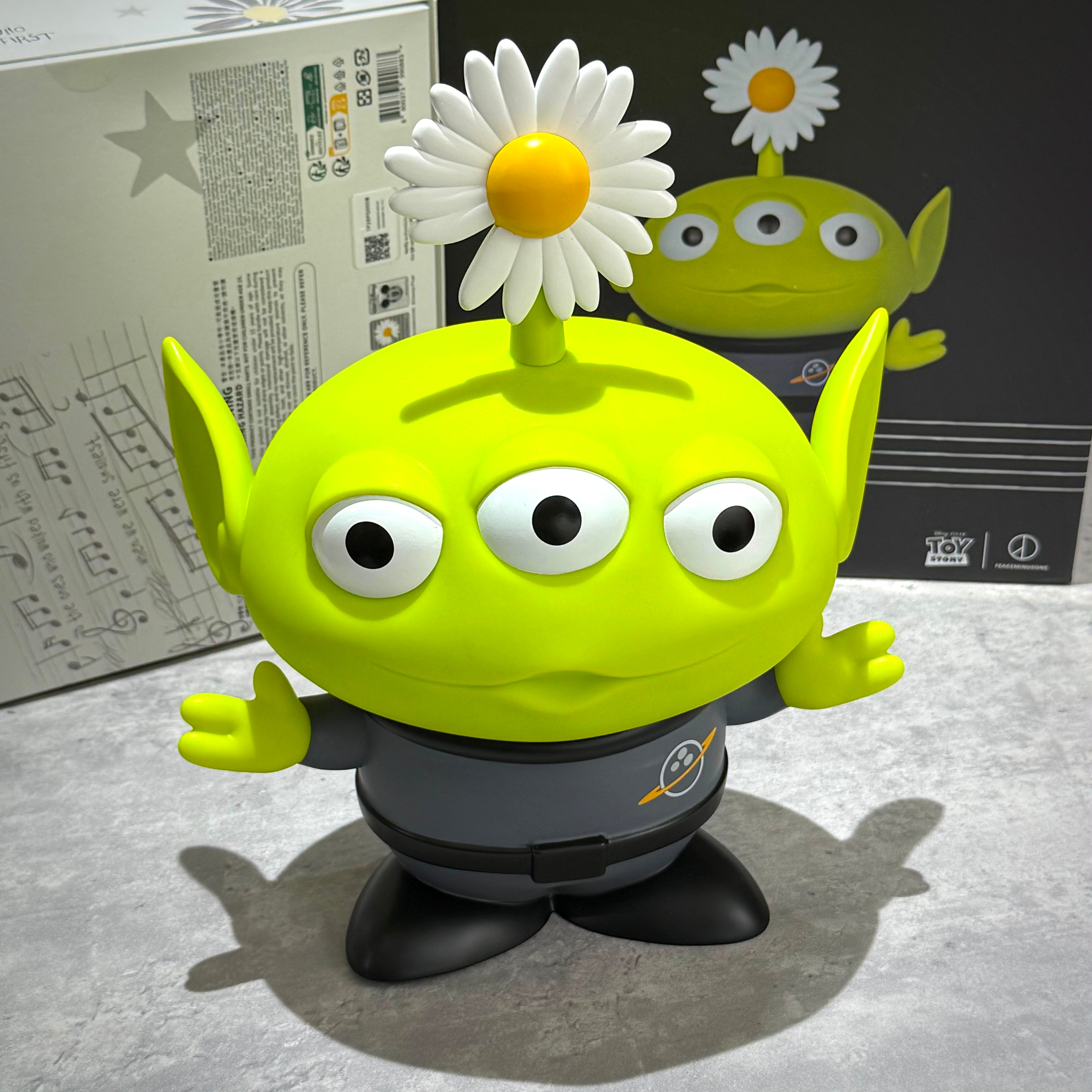PEACEMINUSONE x Toy Story The First Fan - Collectable Toy Alien with a daisy on its head, vibrant green design.