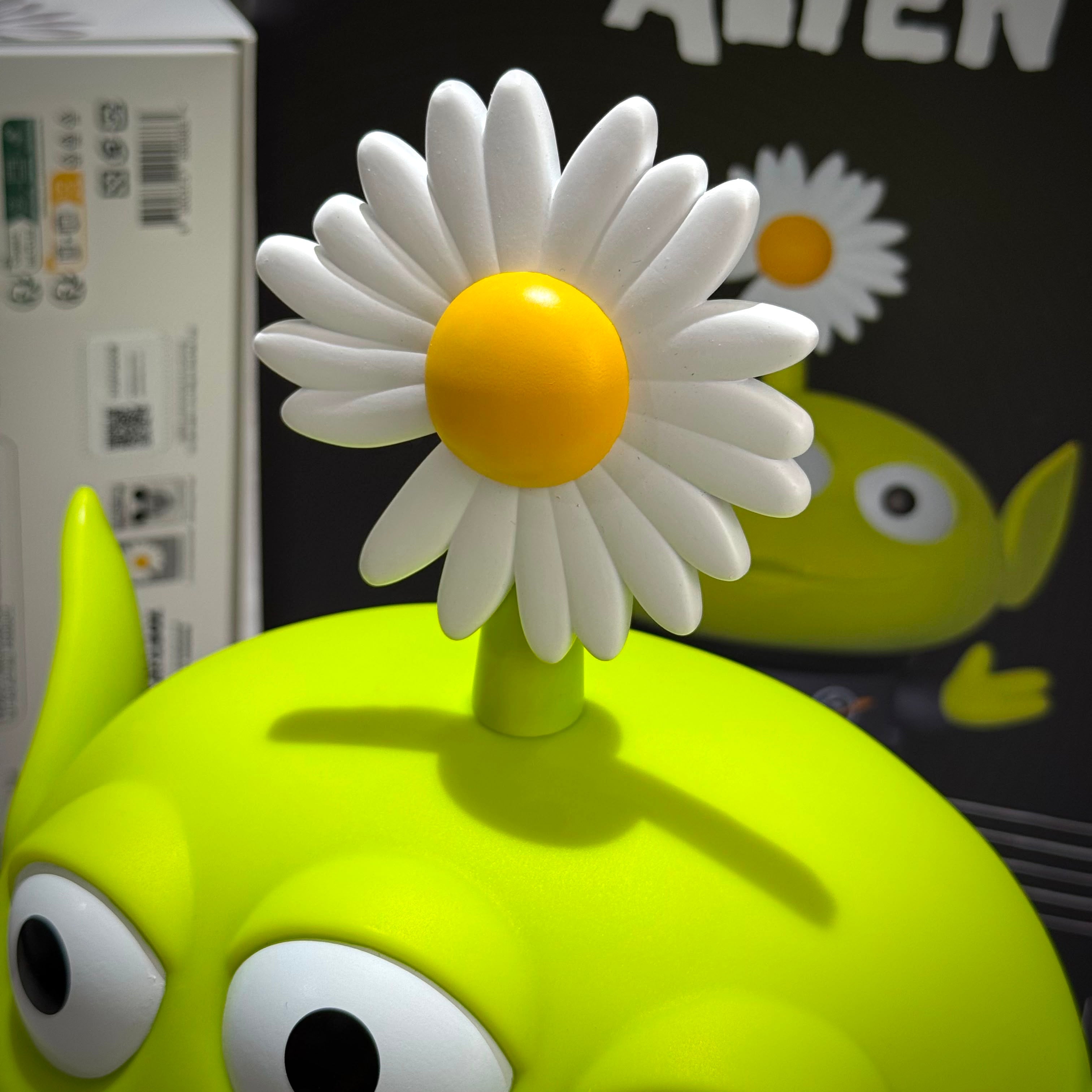 PEACEMINUSONE x Toy Story The First Fan - Collectable Toy Alien with daisy flower on top.