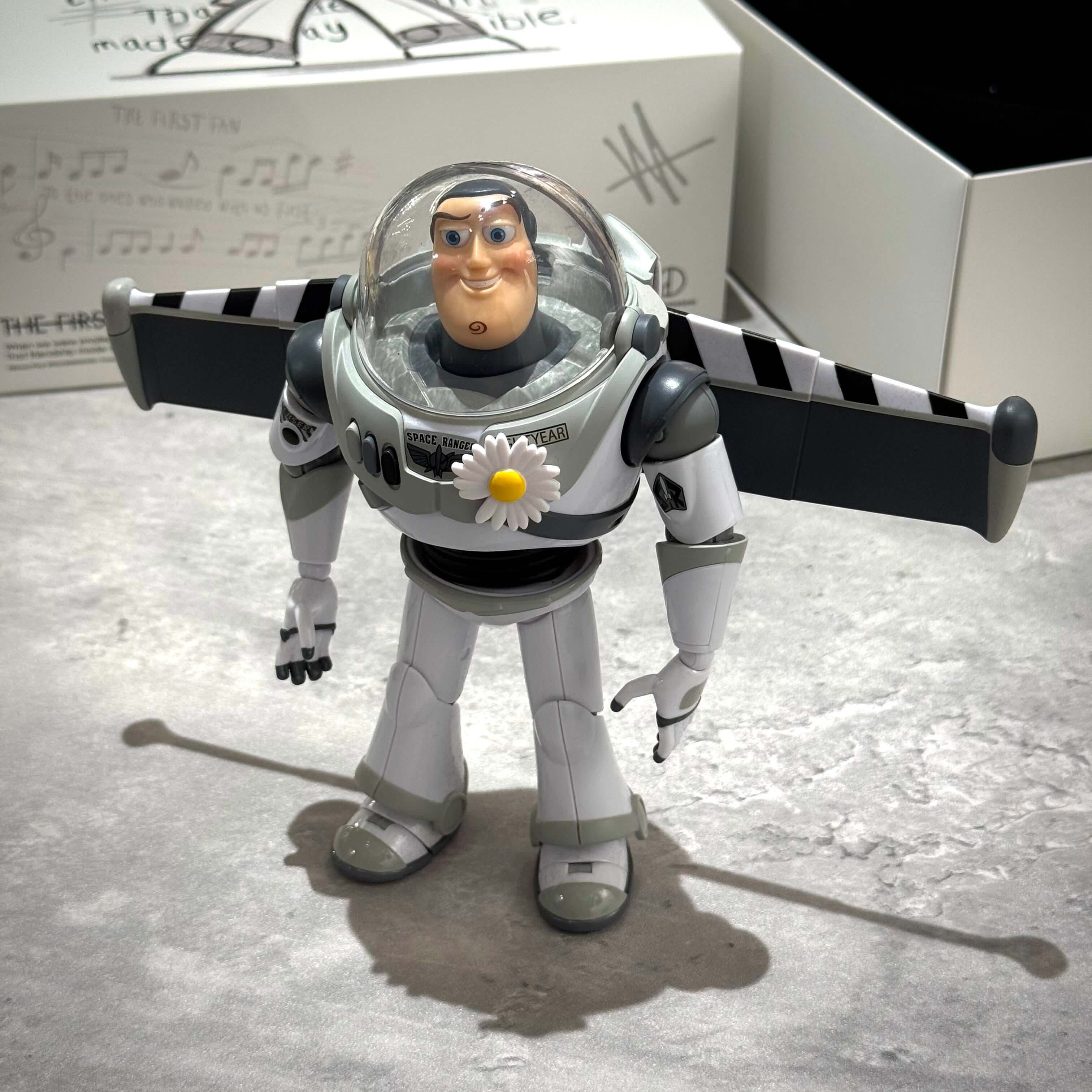 PEACEMINUSONE x Toy Story The First Fan - Action Figure Buzz standing with wings extended on a tabletop.
