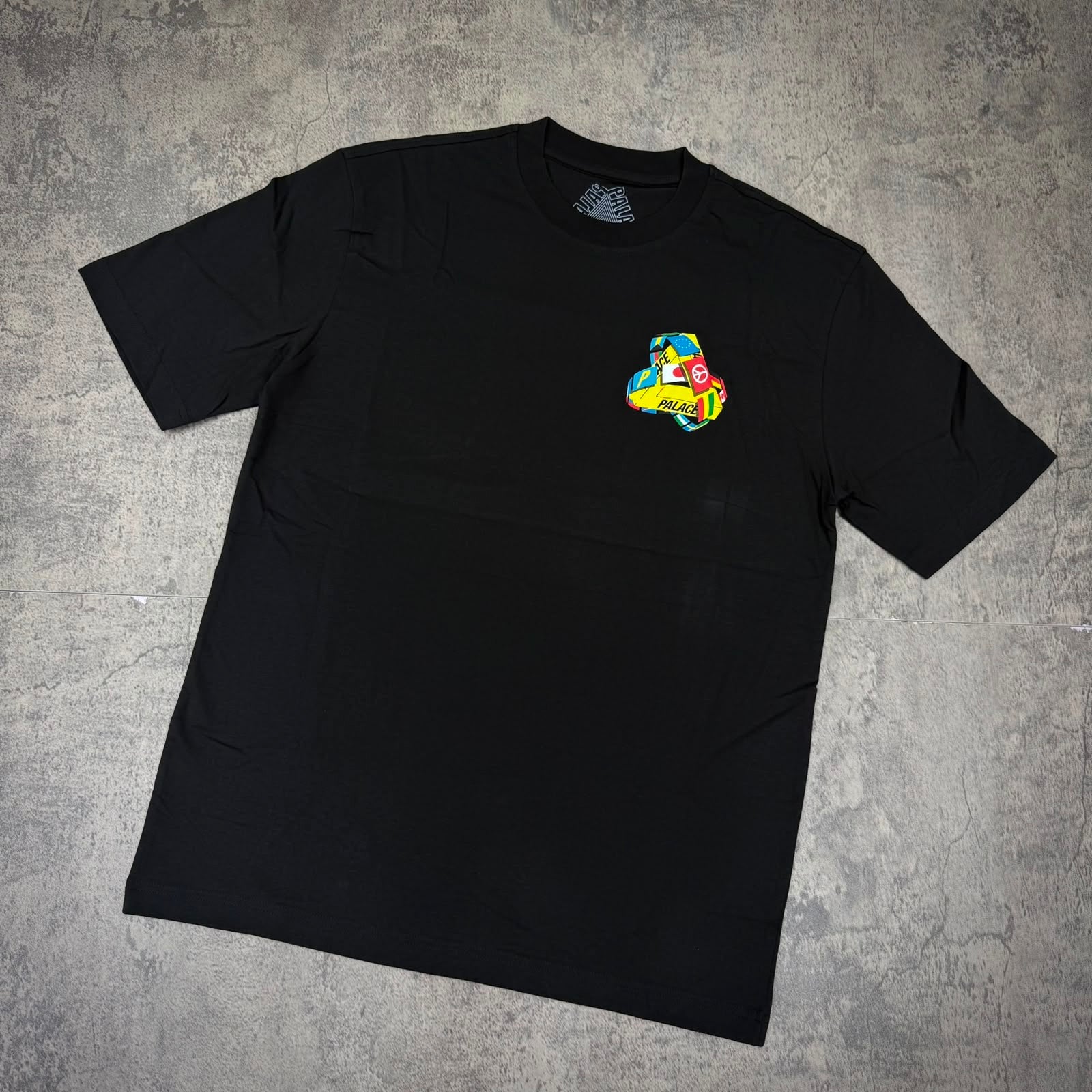 Palace Tr-Flag Tee - Black featuring a colorful graphic on a black tee.