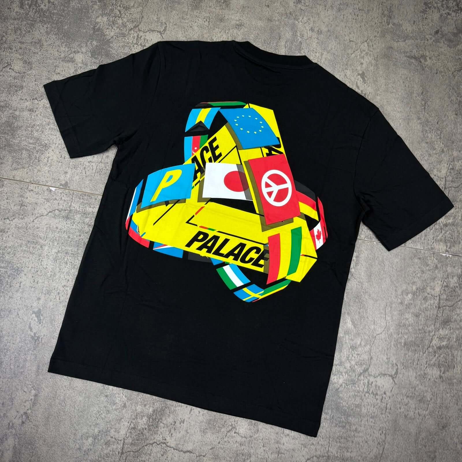 Palace Tri-Flag Tee - Black featuring colorful graphics on the back with the Palace logo.