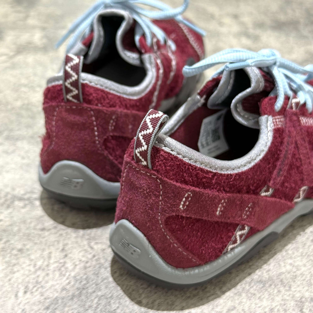 SUNLOVETOUR x New Balance MT1001ND red sneakers with blue laces and rugged sole, showcasing all-terrain design.