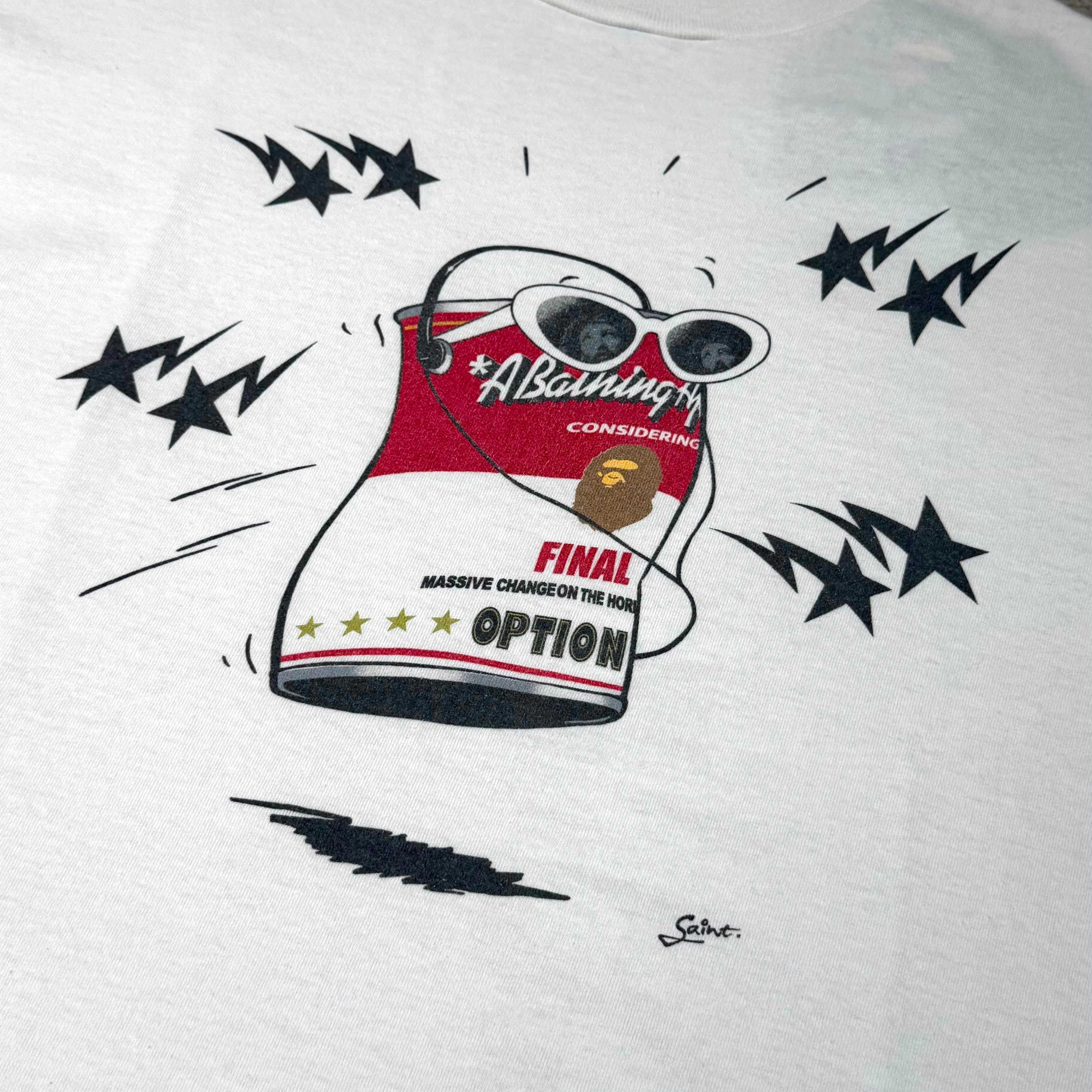 Saint Mxxxxxx BAPE Jump Tee design featuring a cartoon can with sunglasses and dynamic star accents.